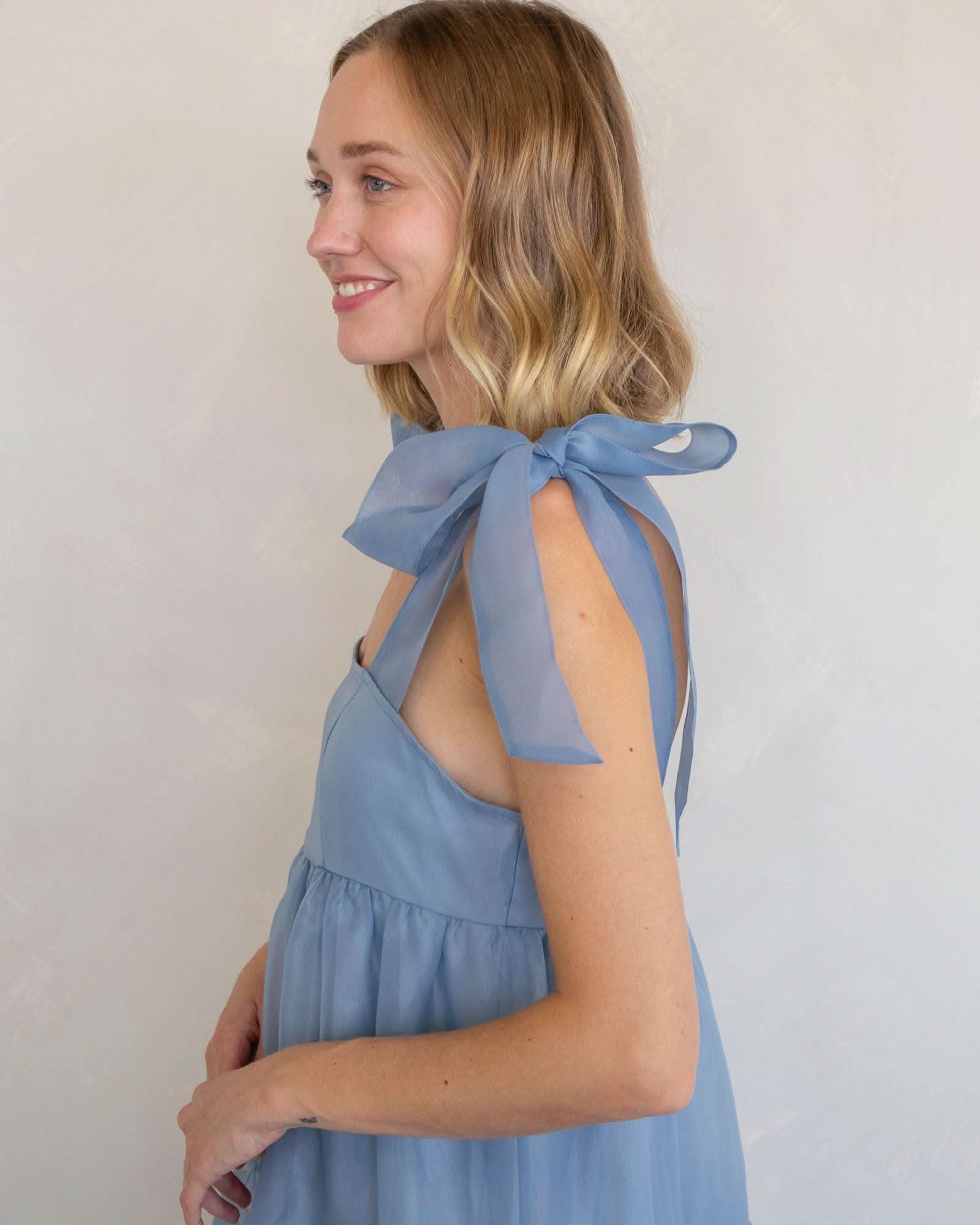 Woman wearing a light blue dress with bow straps