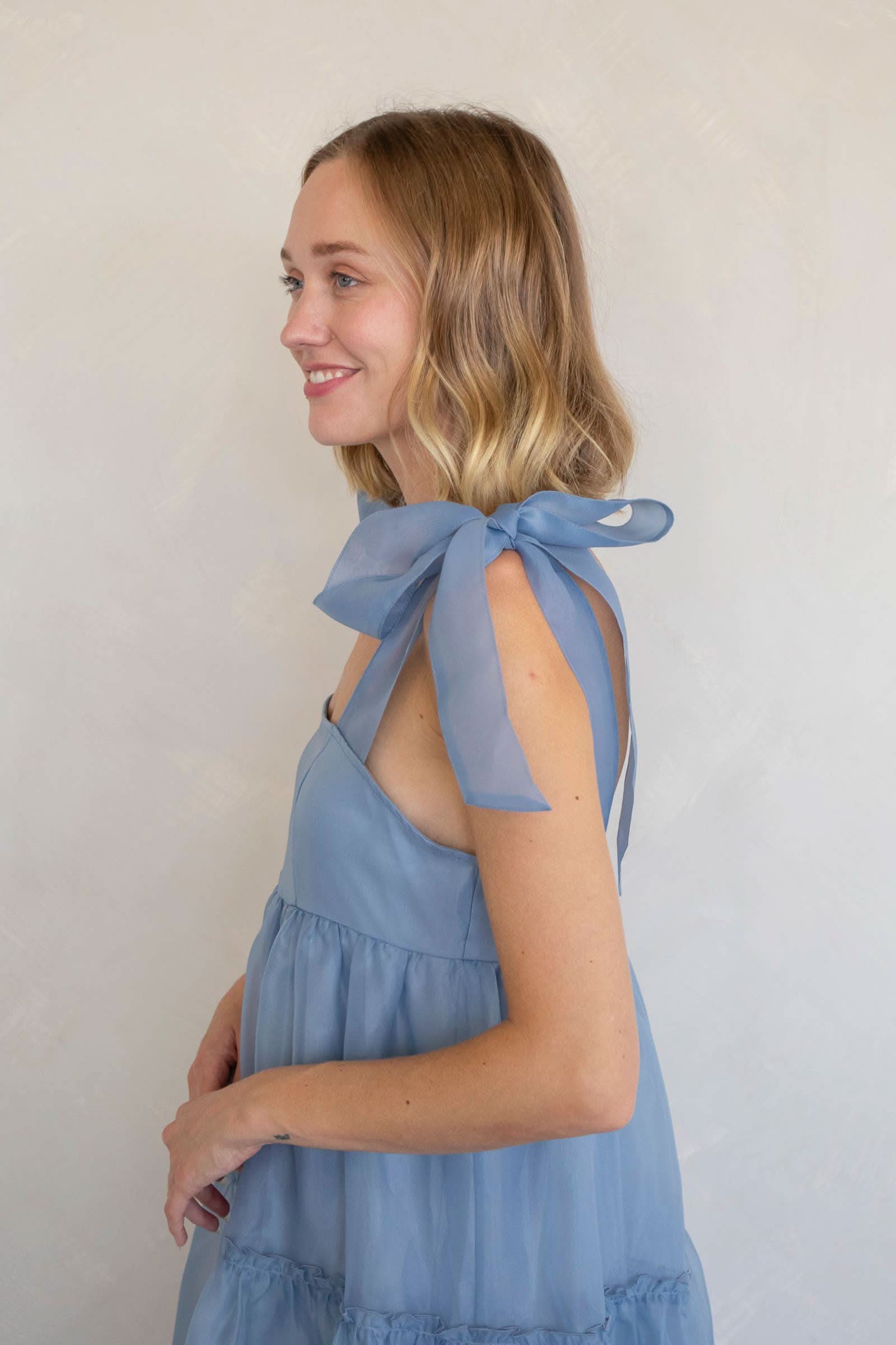 Woman wearing a light blue dress with bow straps