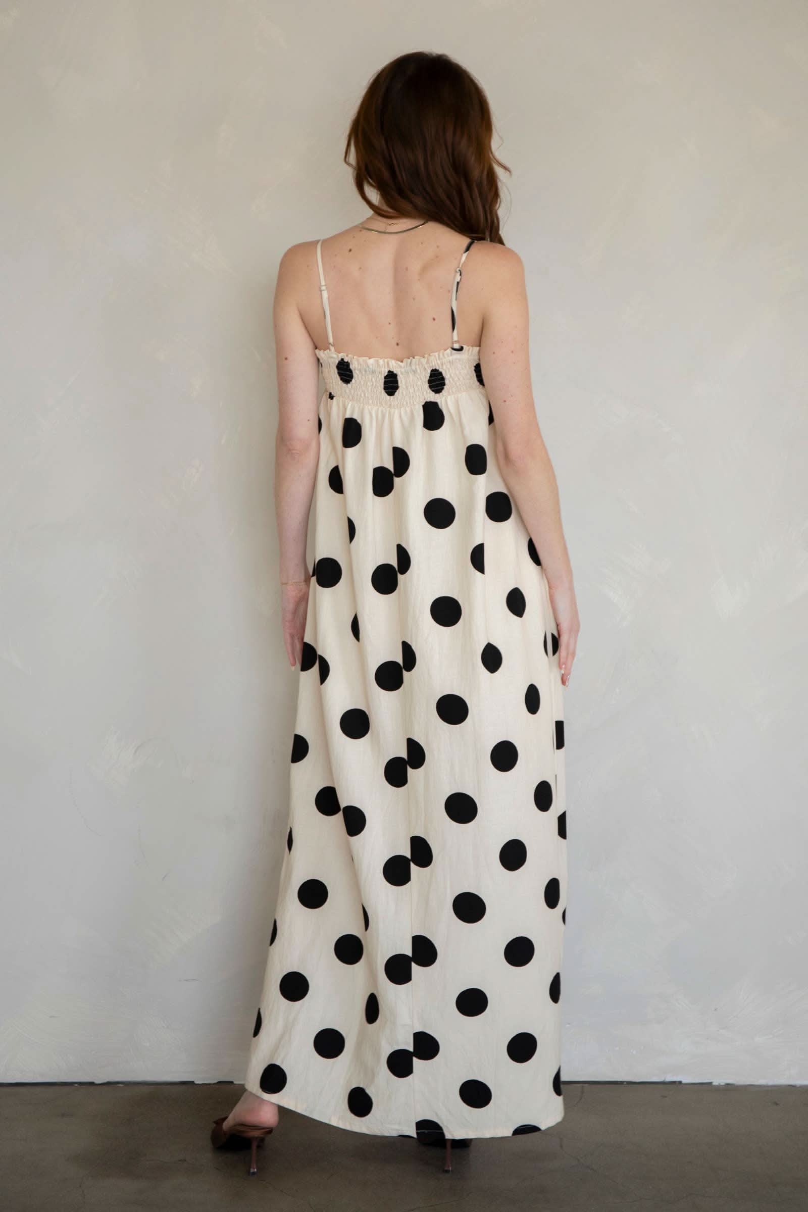 Woman wearing a polka dot dress against a plain background