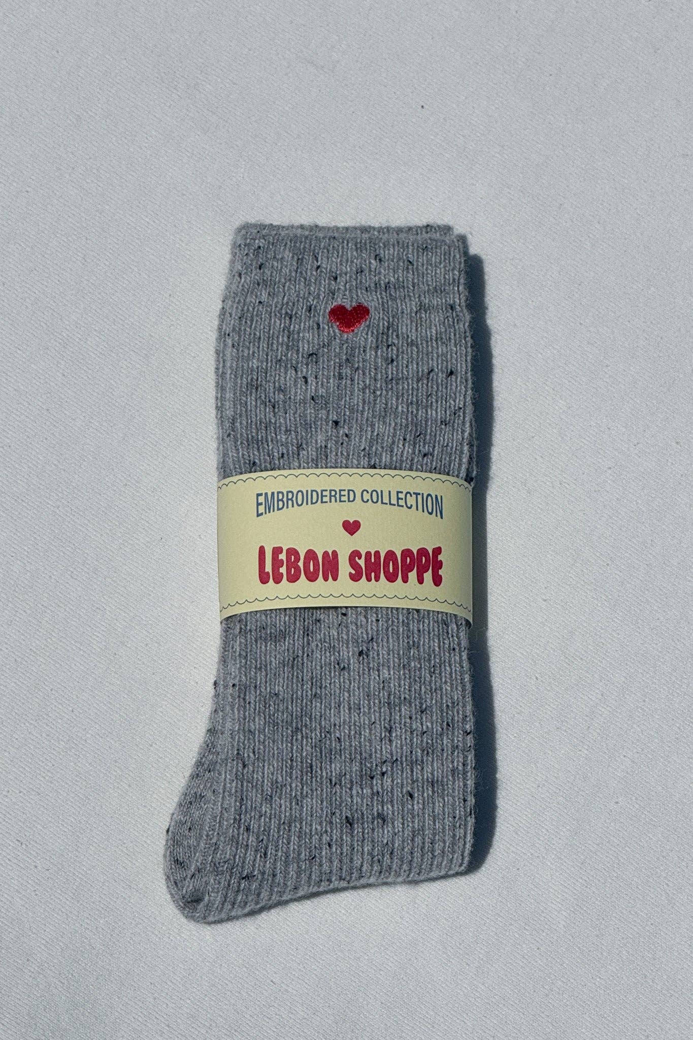 Gray sock with a red heart and 'Lebon Shoppe' label on a light gray background