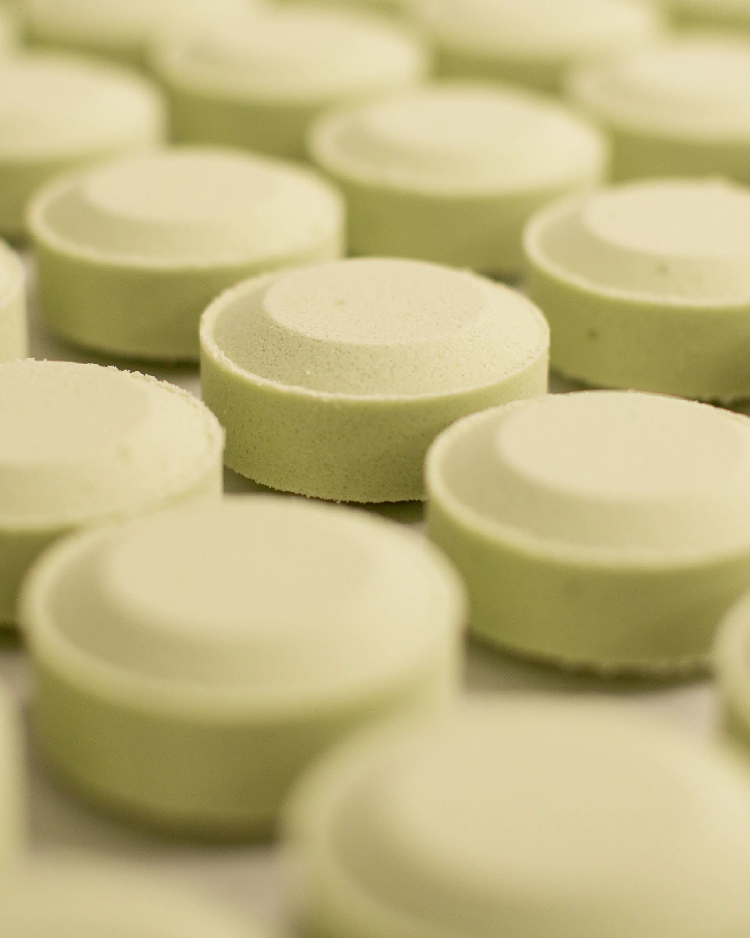 Green eucalyptus shower tablets lined up in rows on a flat surface
