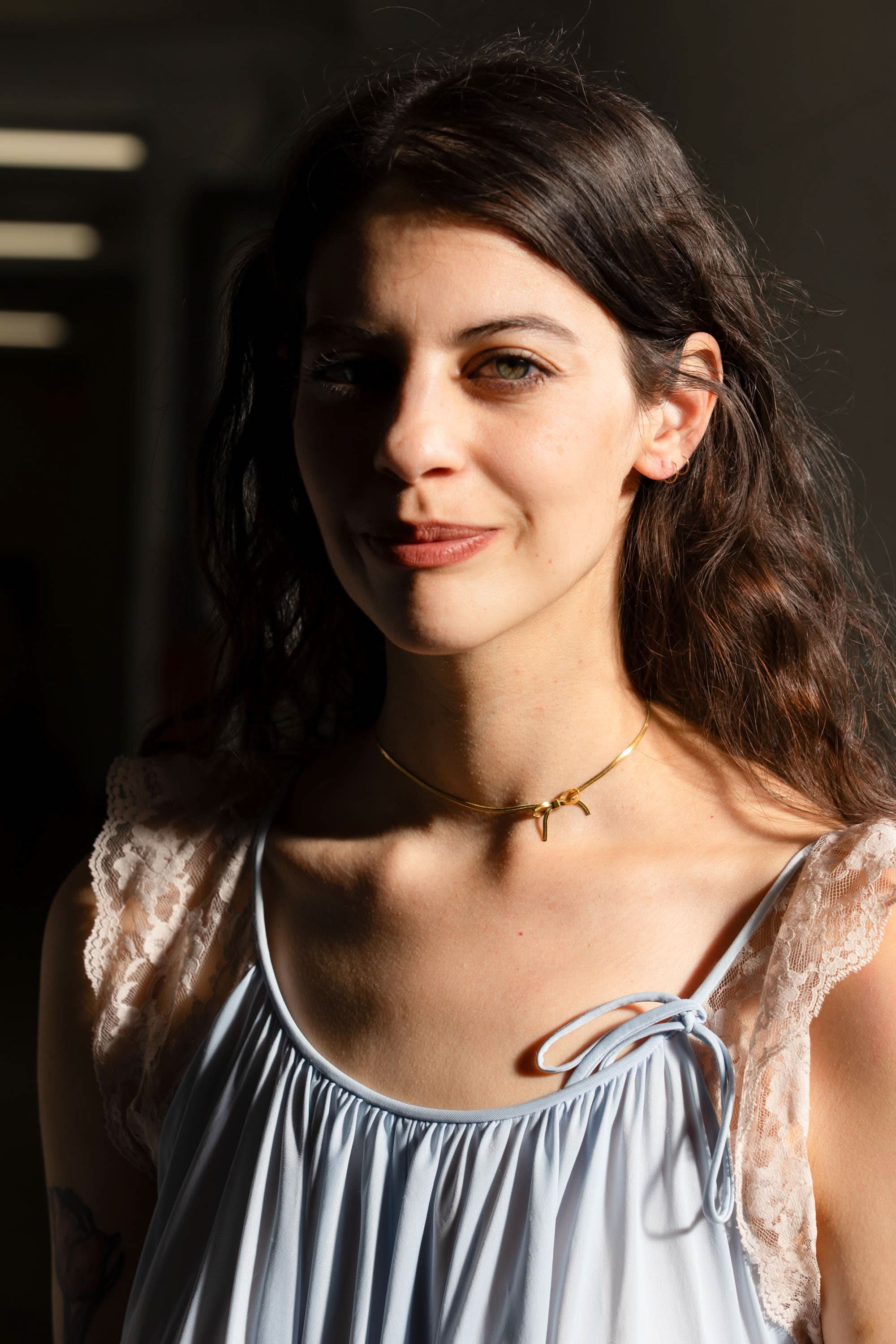 woman wearing gold bow chocker necklace