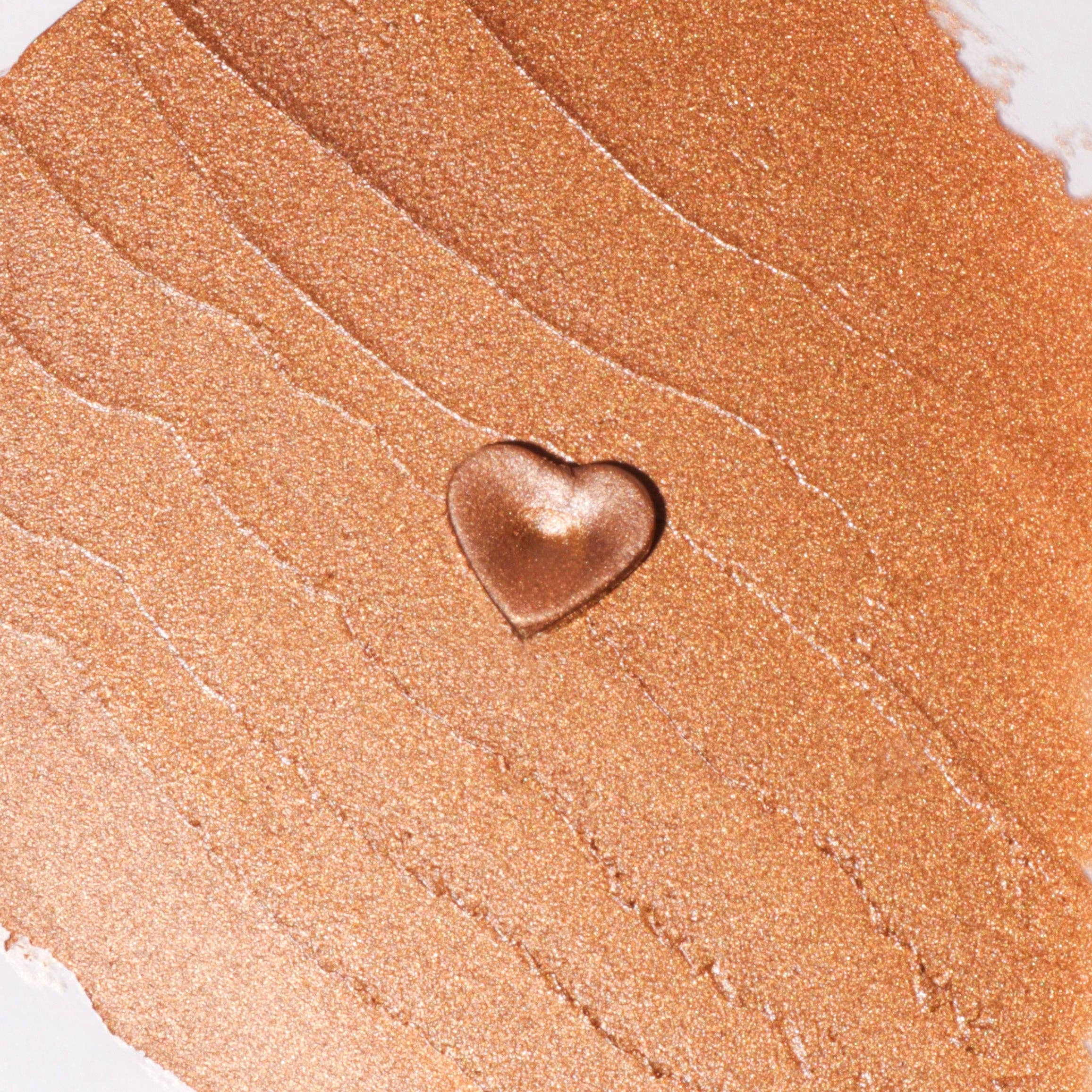 Heart-shaped gold object on a brown textured surface