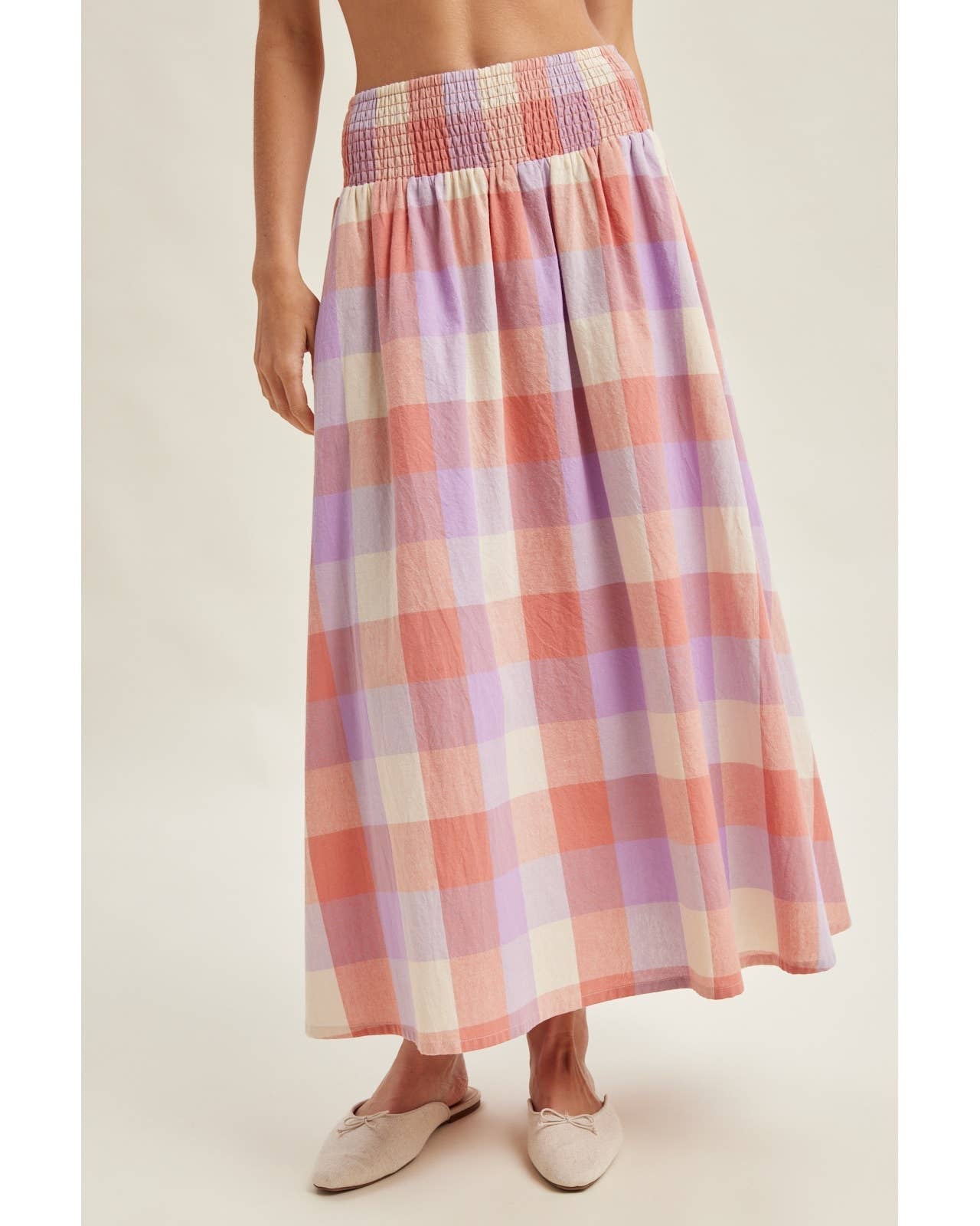 Person wearing a plaid skirt on a plain background