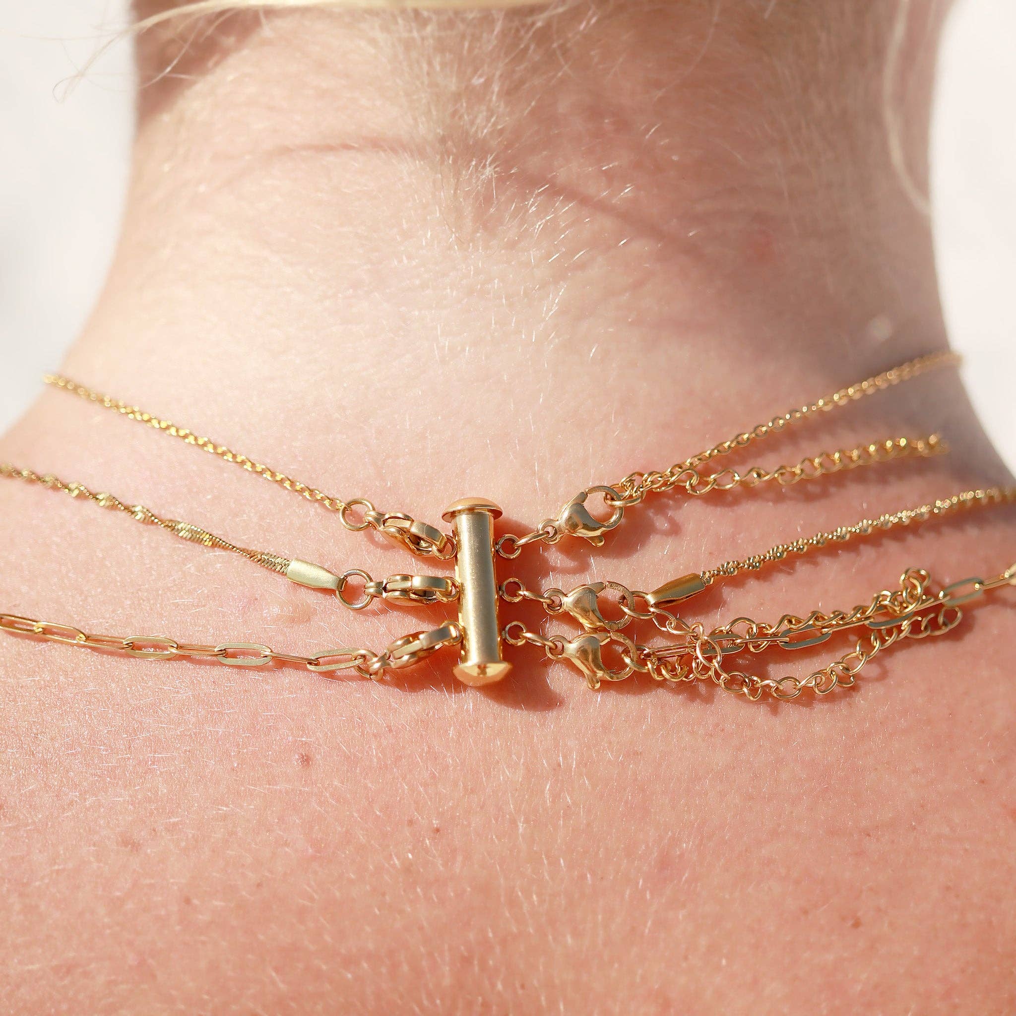 Close-up of a person's wrist wearing multiple gold bracelets.