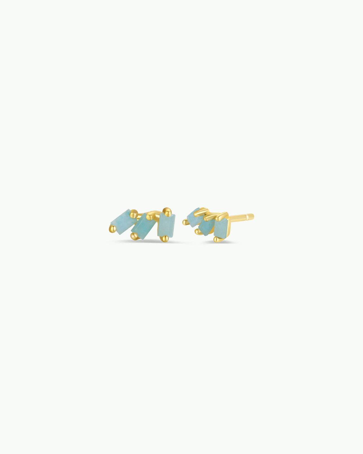 Gold earrings with blue stones on a white background