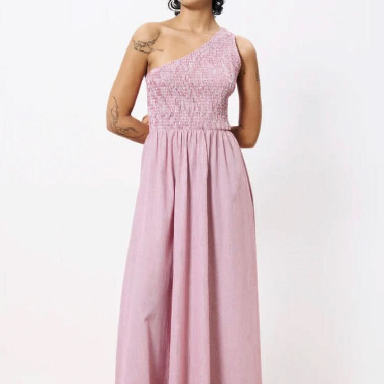 Woman wearing a pink one-shoulder dress against a white background