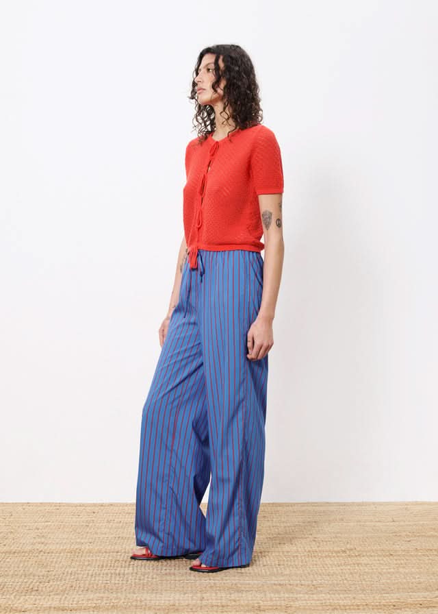 Red top and blue frnch-edeline pants with red vertical stripes all over