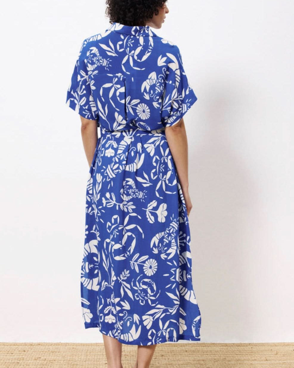 Woman wearing a blue floral dress against a white background