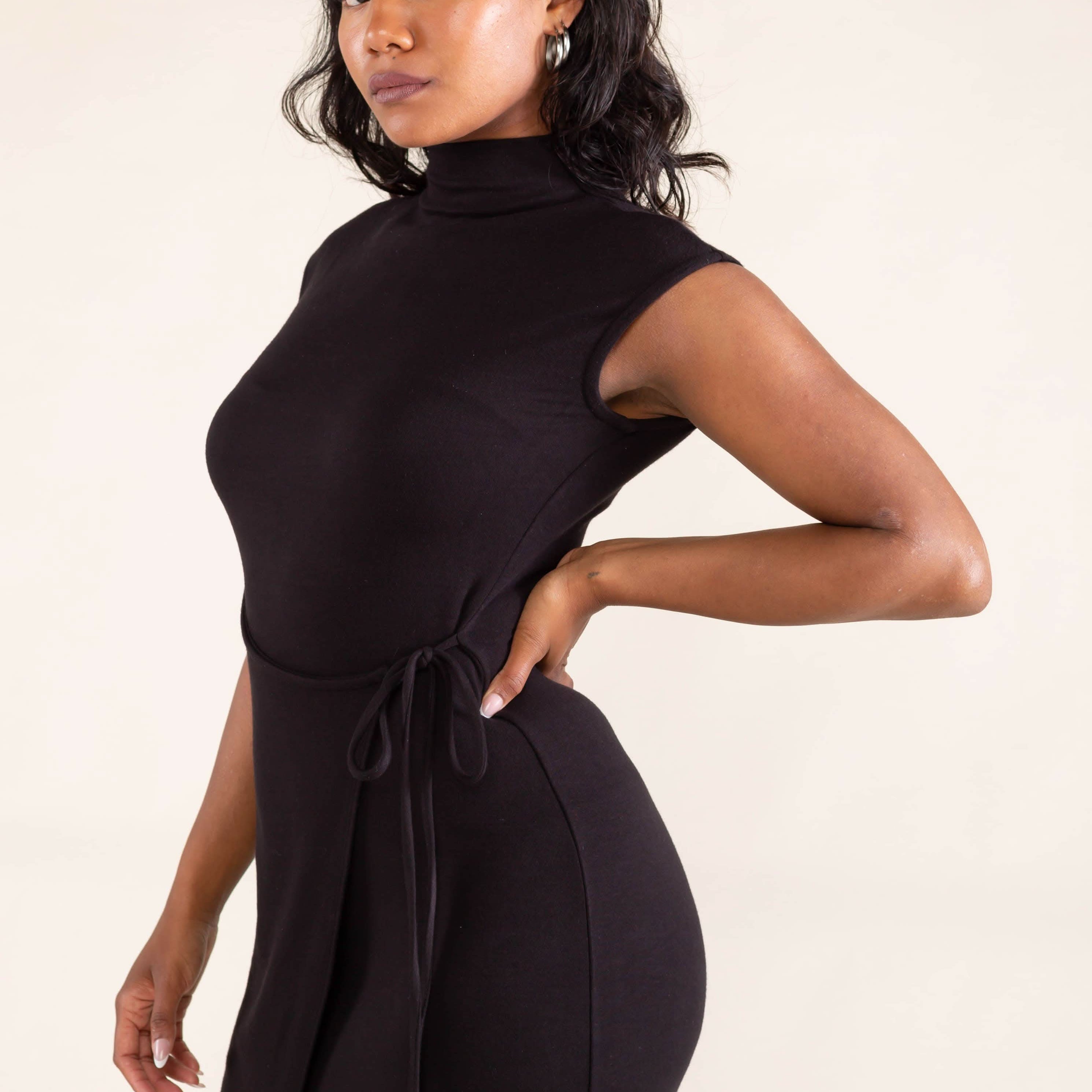 Woman wearing a black sleeveless dress against a beige background