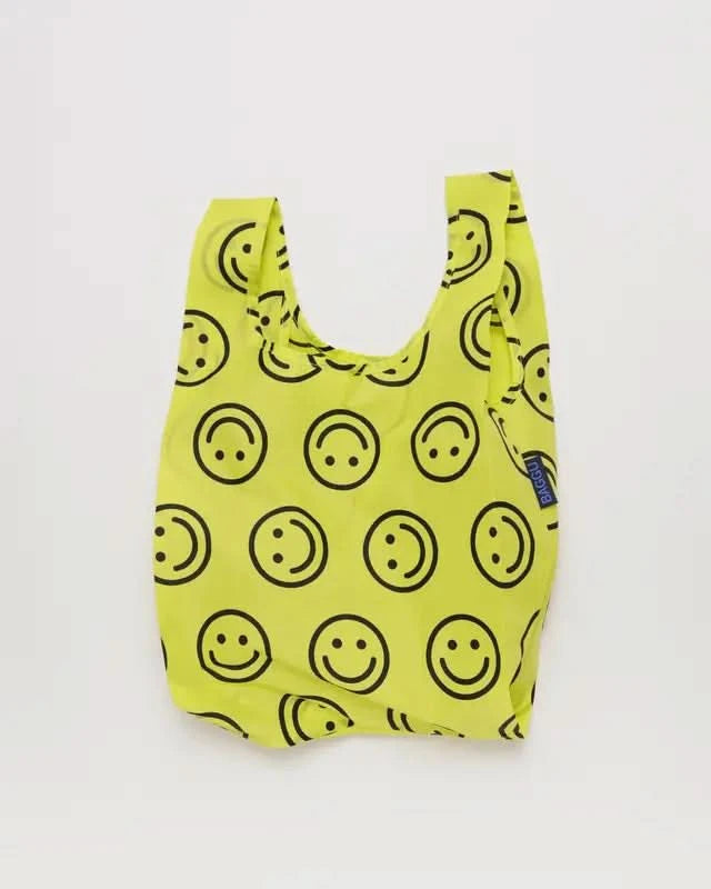 Neon yellow smiley face reusable BAGGU bag on white background