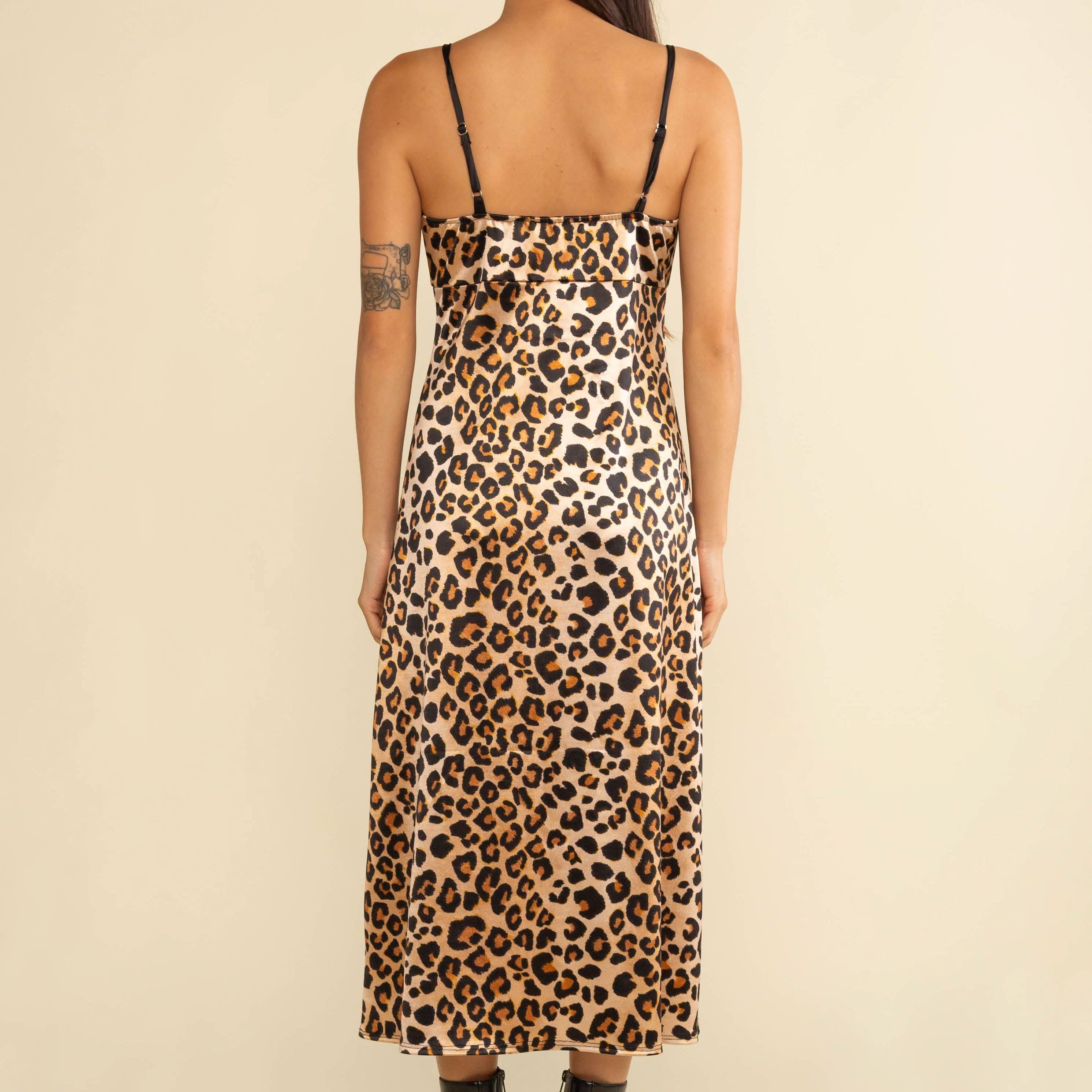 Person wearing a leopard print dress on a beige background