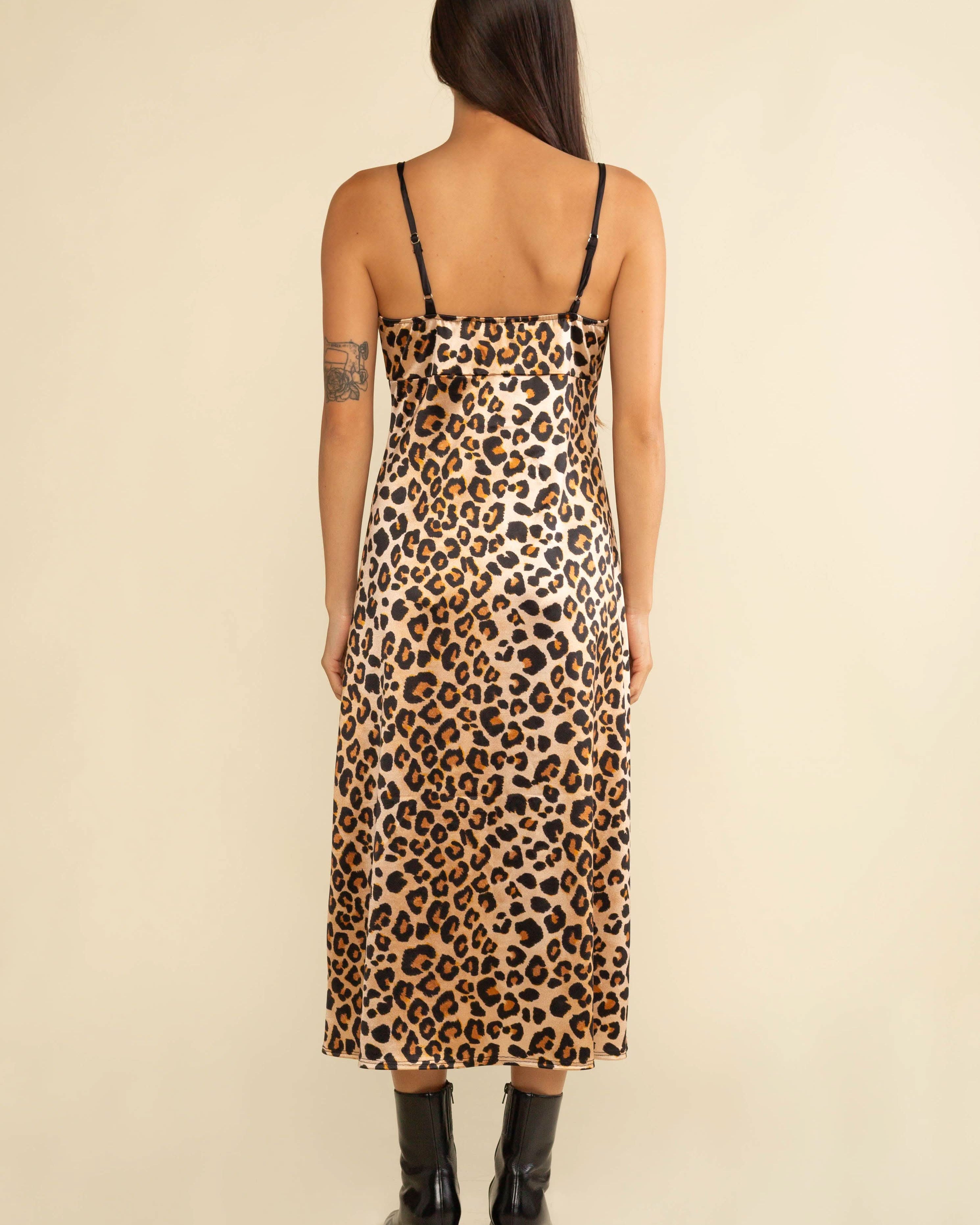 Person wearing a leopard print dress on a beige background