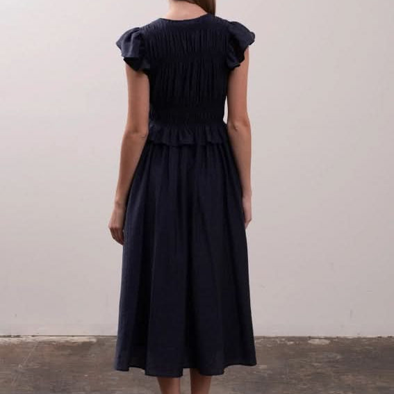 Woman wearing a black dress with puffed sleeves Moon River Shirred Ruffle Midi Dress