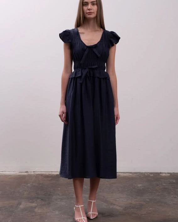 Woman wearing a dark blue dress Moon River Shirred Ruffle Midi Dress