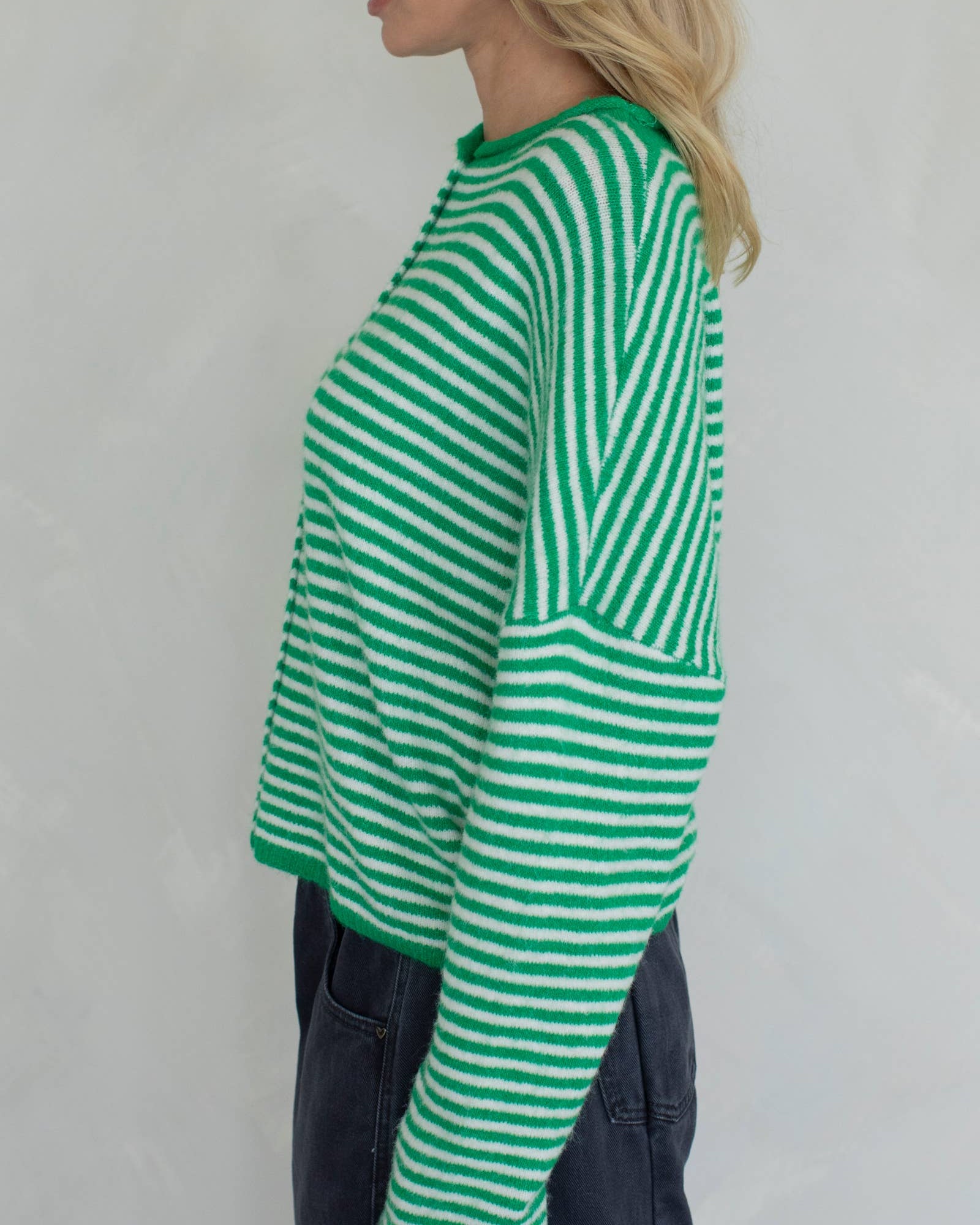 Person wearing a green and white striped sweater and see left side