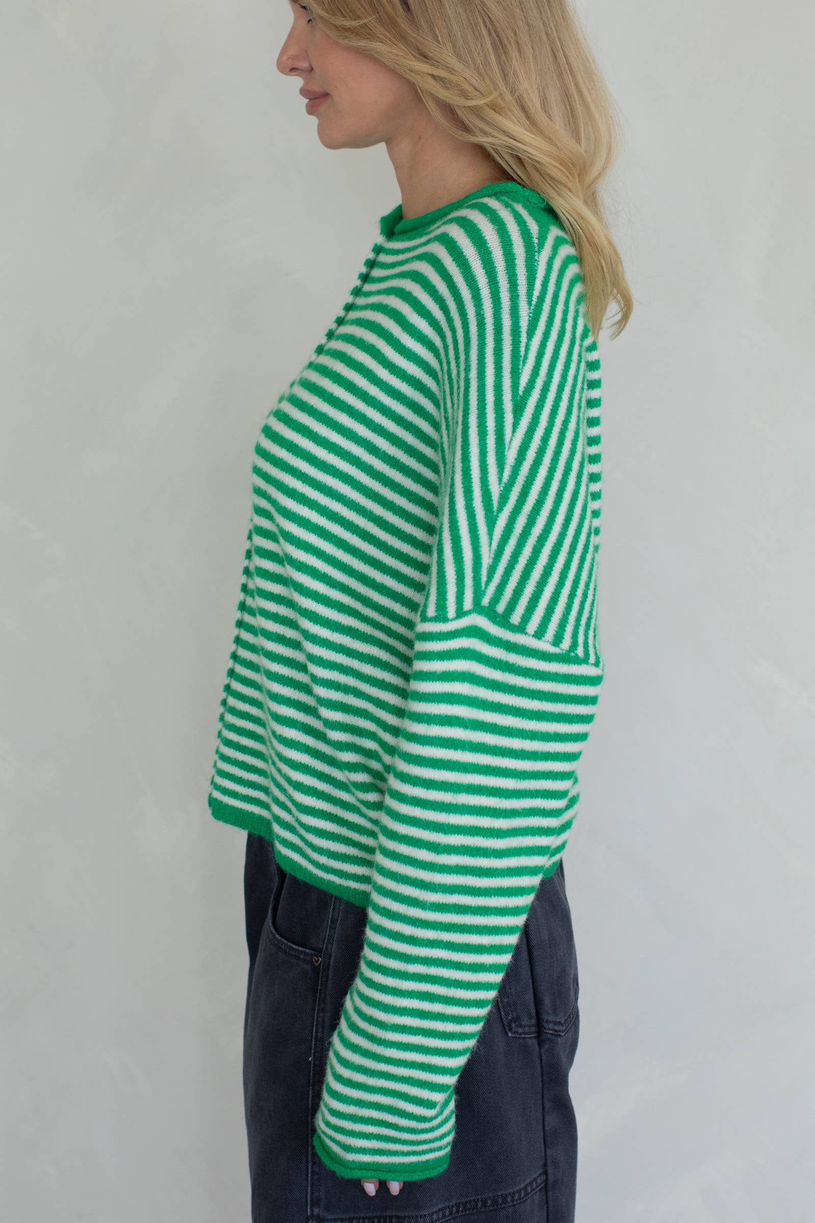Person wearing a green and white striped sweater and see left side