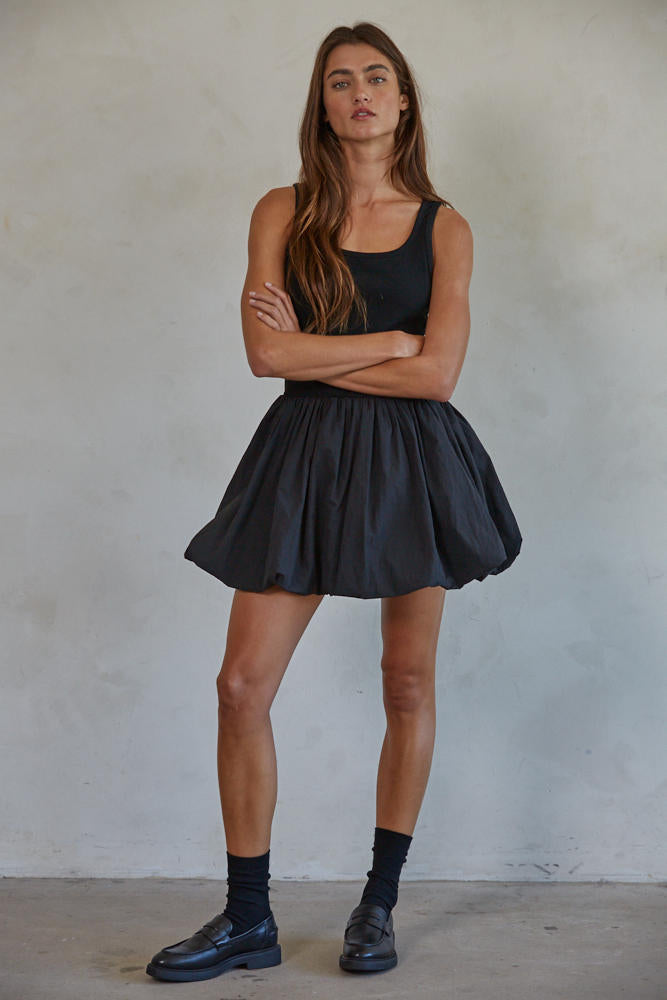 Woman wearing a black sleeveless top and black shoes