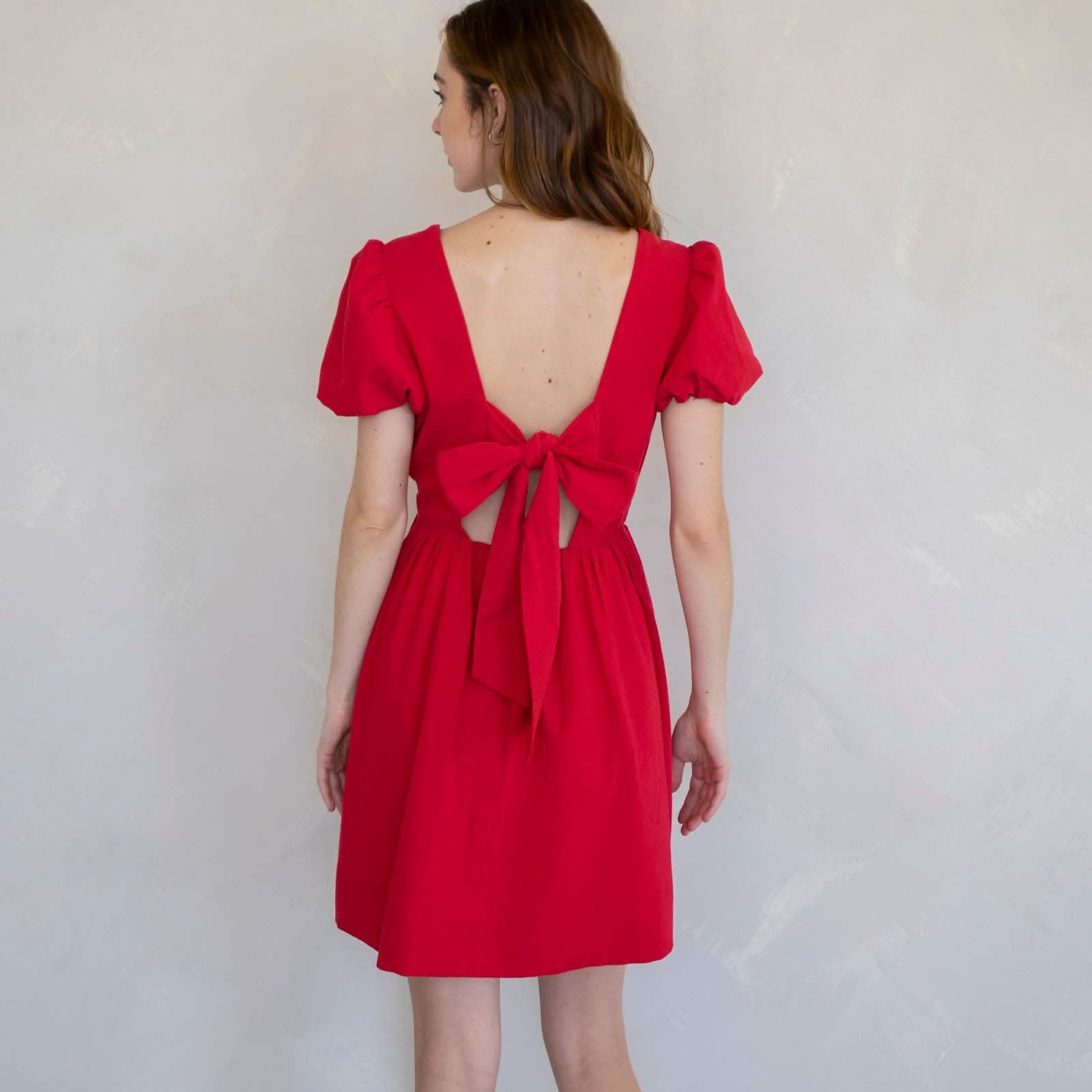 Woman wearing a red dress with a cutout back