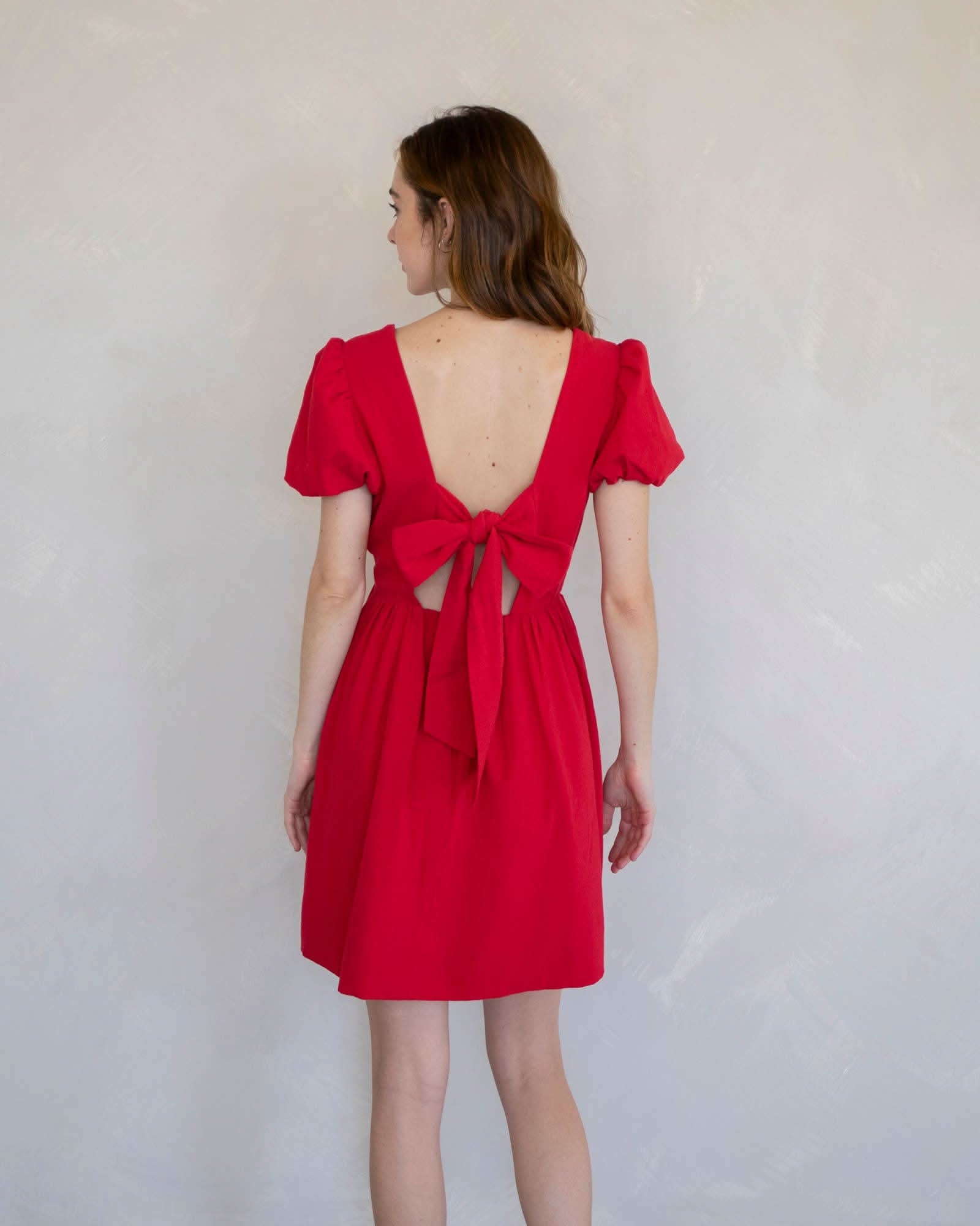 Woman wearing a red dress with a cutout back