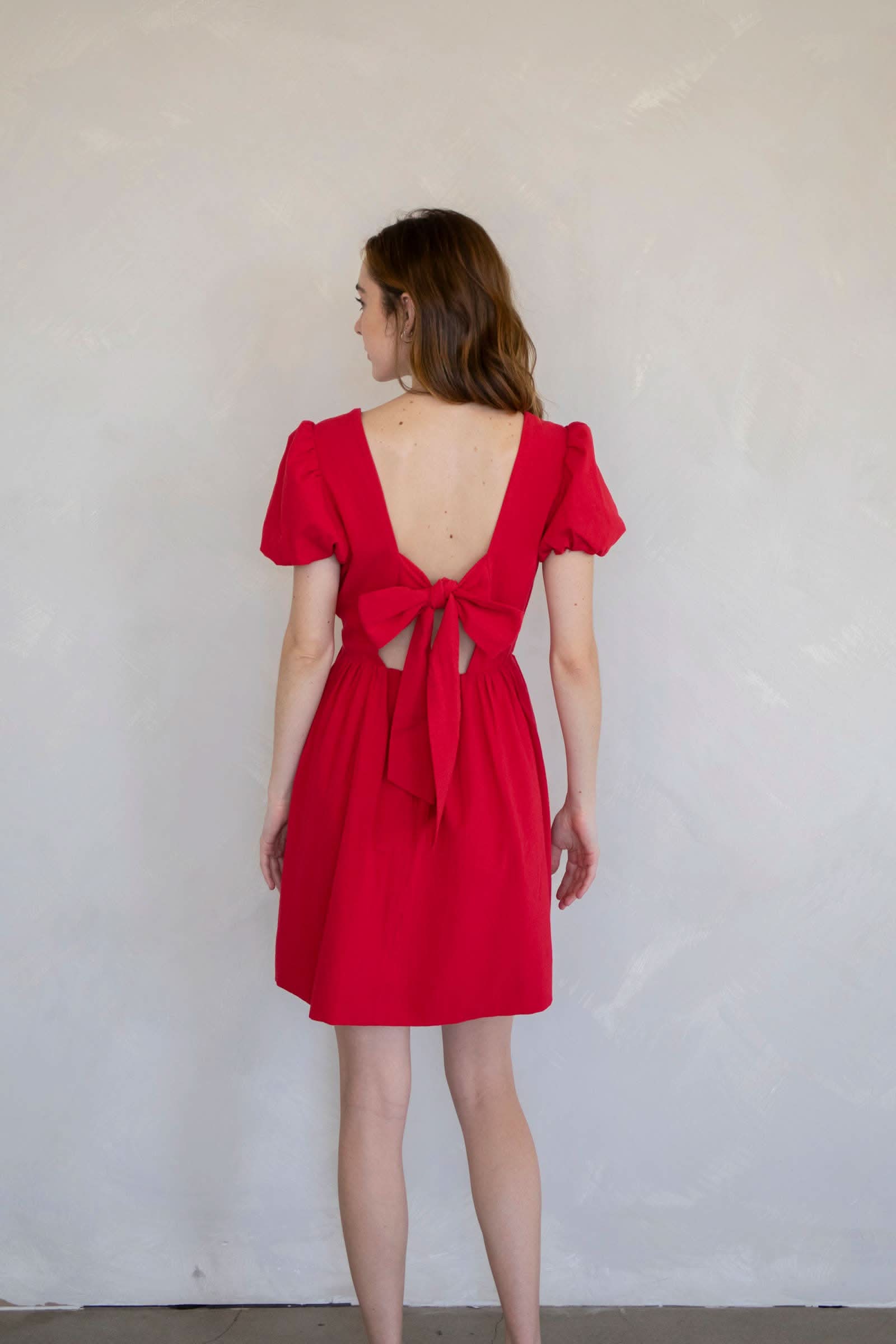 Woman wearing a red dress with a cutout back