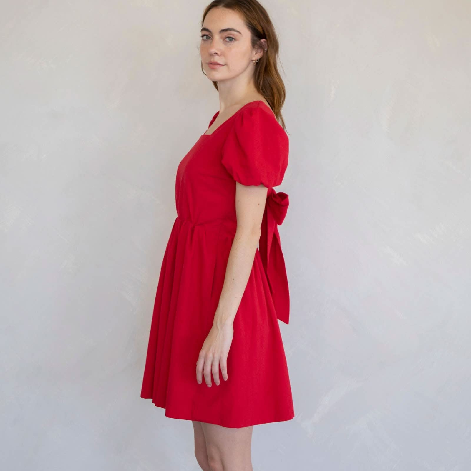 Woman wearing a red dress side face view dress