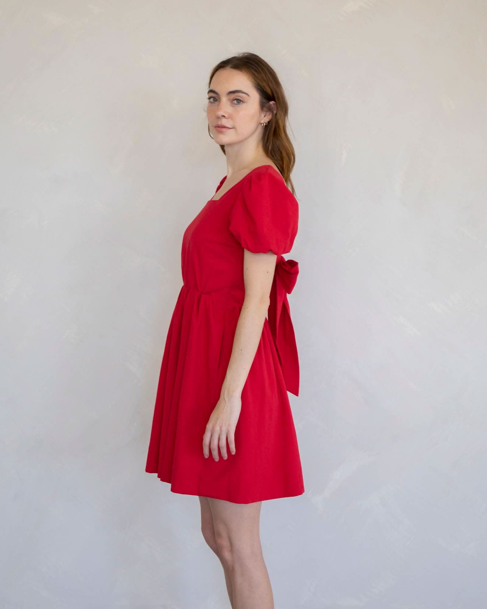 Woman wearing a red dress side face view dress