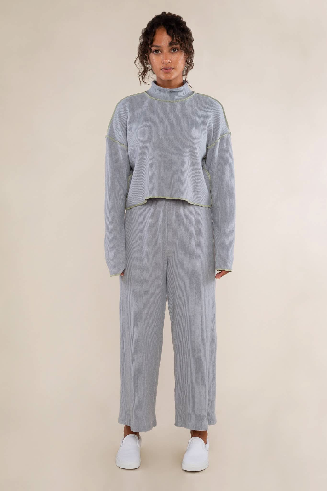 Person wearing a light gray cropped turtleneck top features delicate pleats