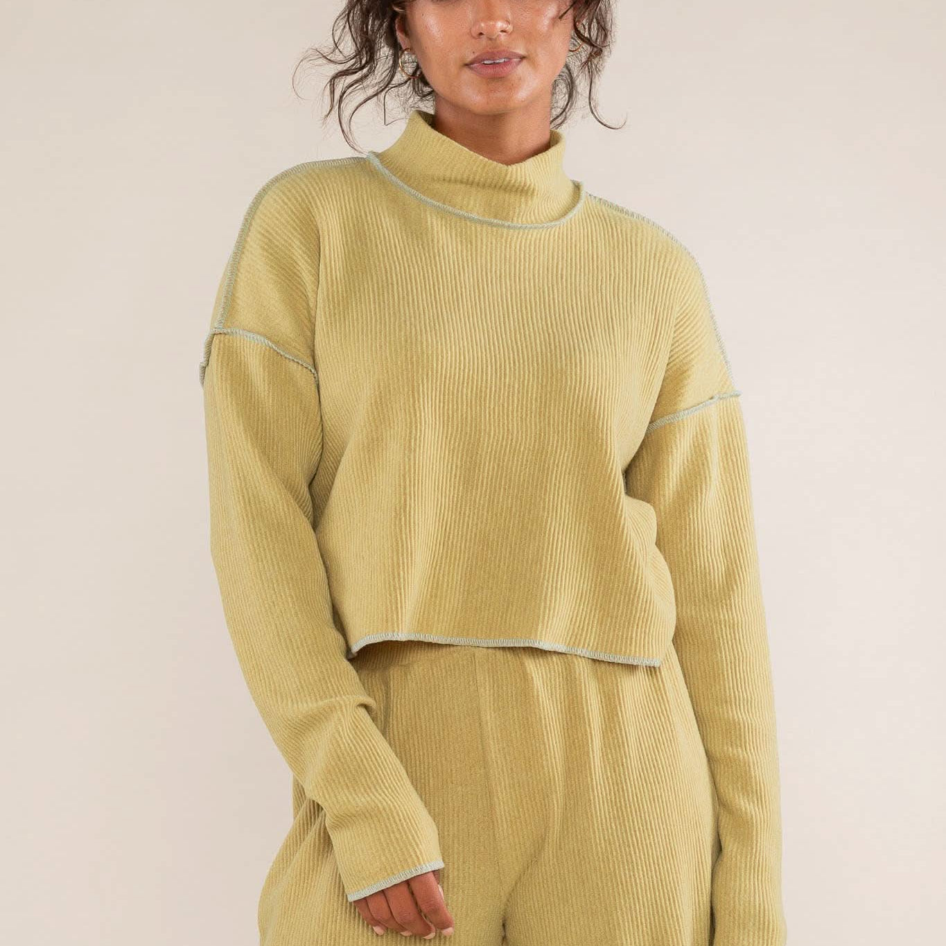 Woman wearing a mustard yellow ribbed knit outfit