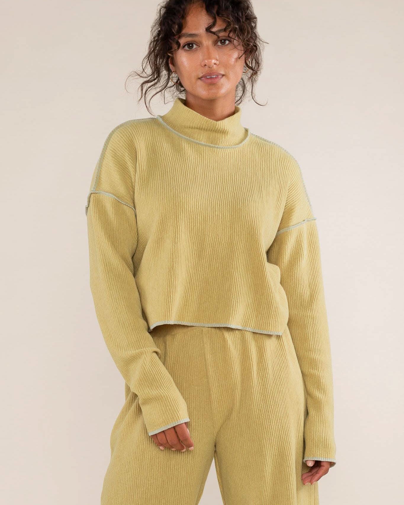 Woman wearing a mustard yellow ribbed knit outfit