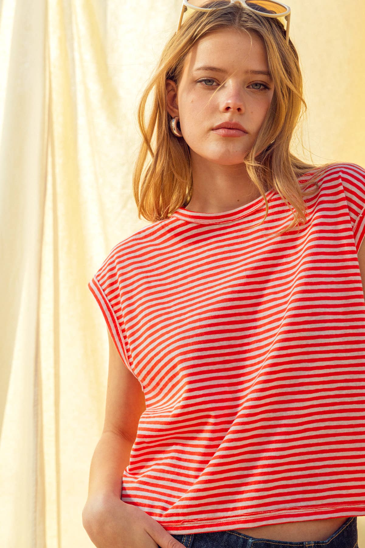 Woman wearing a red and white striped shirt against a light background