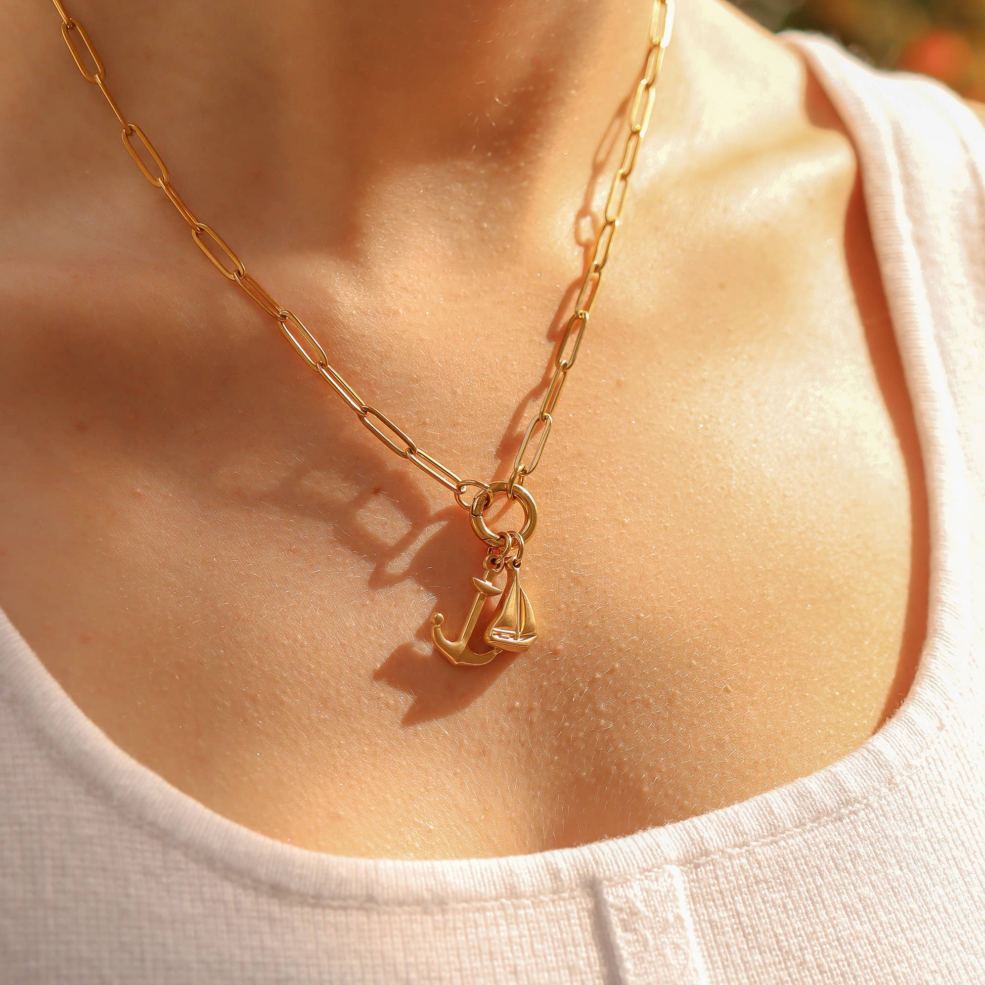 Gold necklace with a pendant worn by a person, close-up shot.