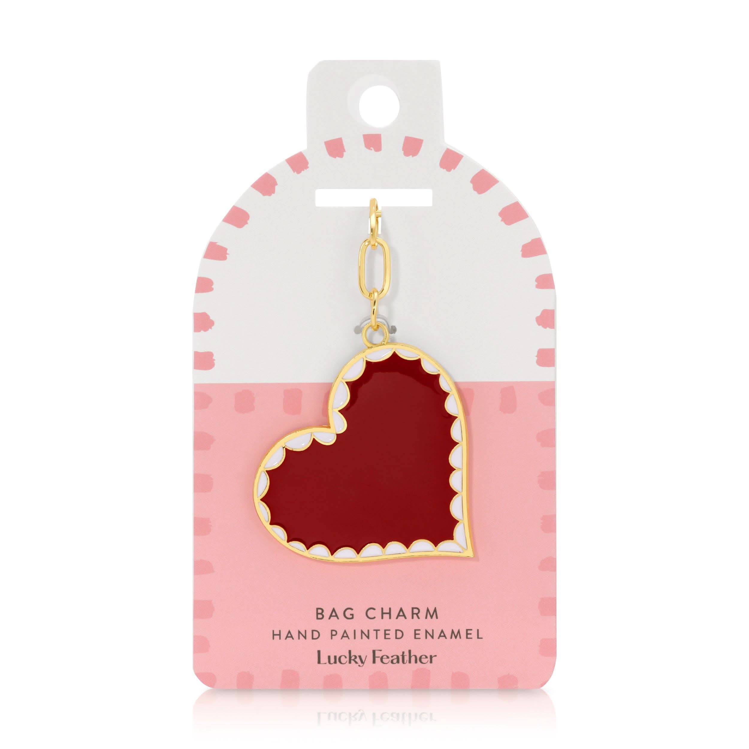 Hand painted enamel red heart bag charm with scalloped white and gold outline detail in pink and white case