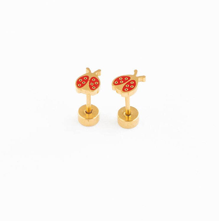 Pair of red and gold ladybug flat back earrings laying on a white surface 