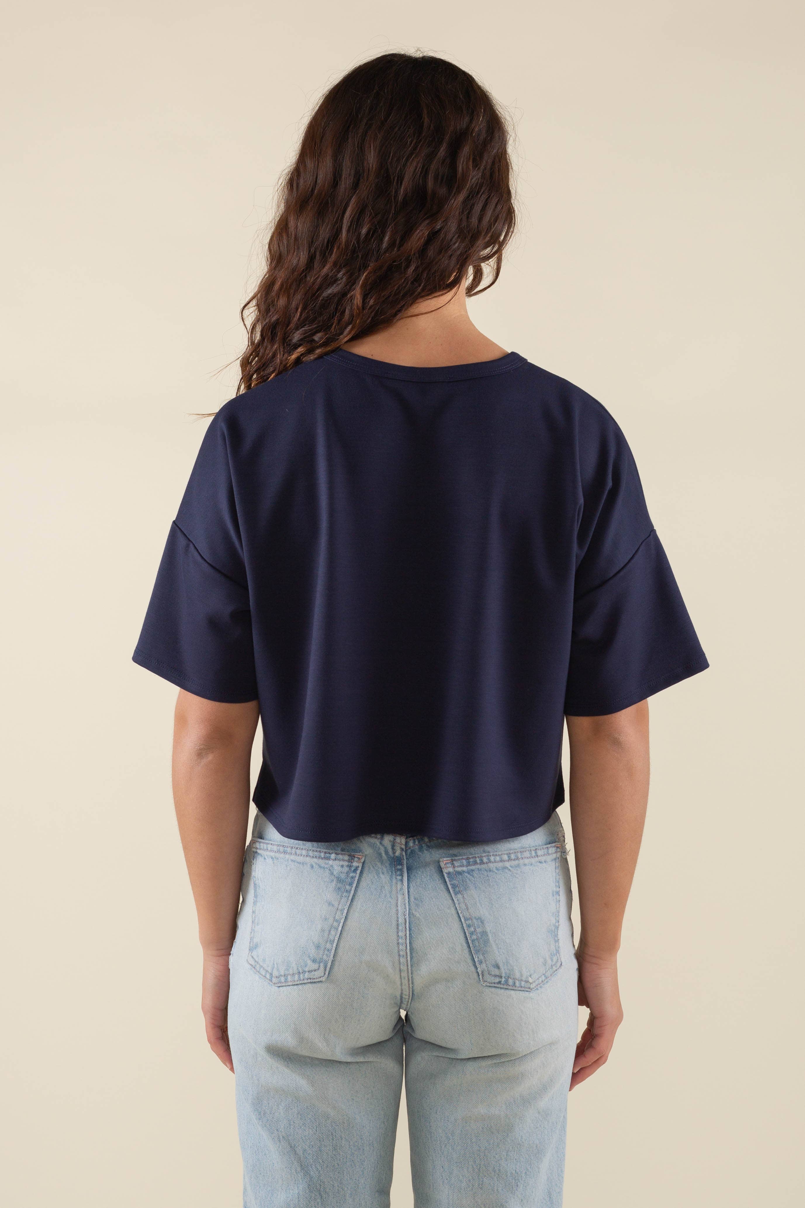 Woman wearing navy, short sleeve, jersey, cropped t-shirt and blue jeans 