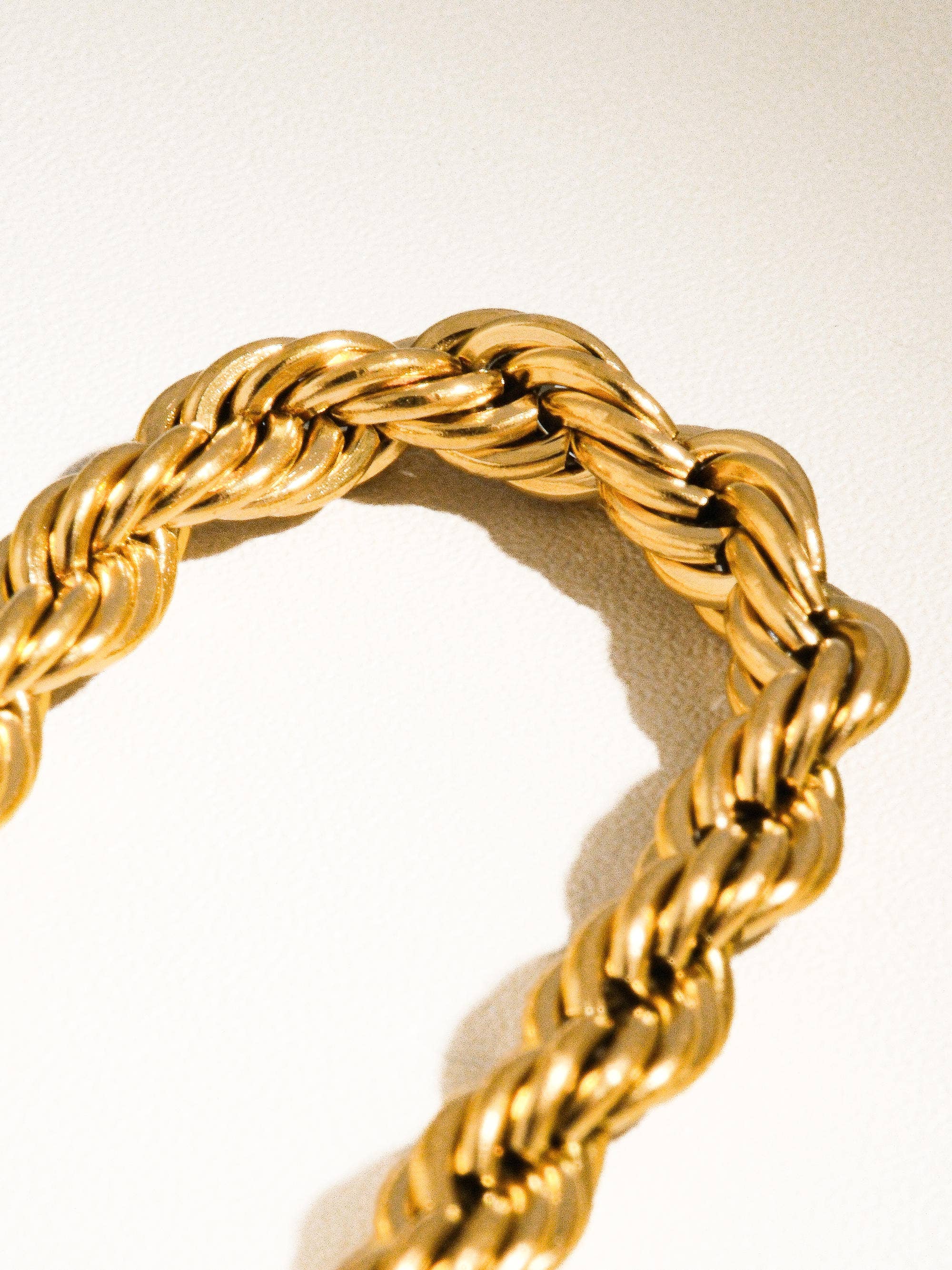 Gold braided ring on a light background