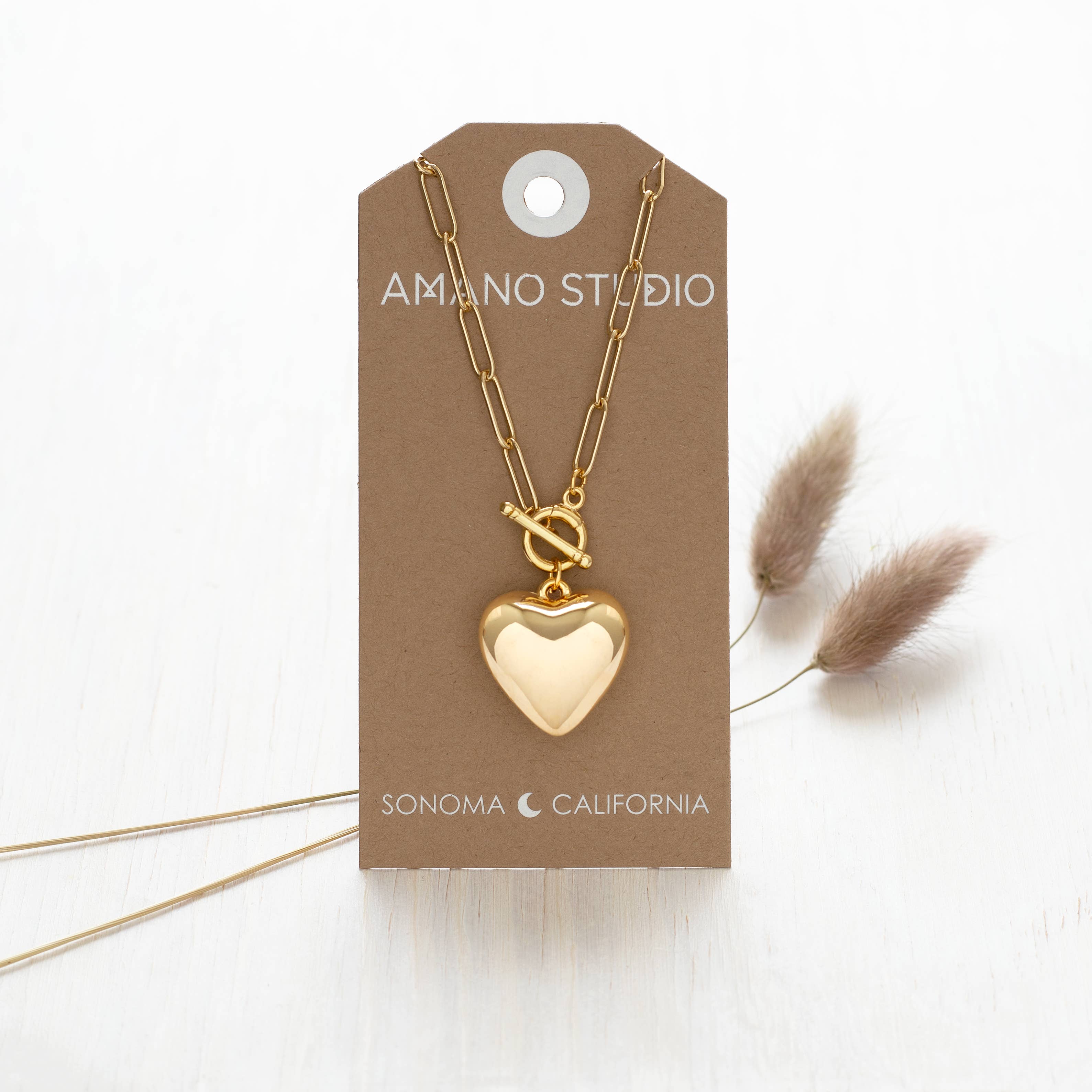 gold 90's puffed heart necklace on stand