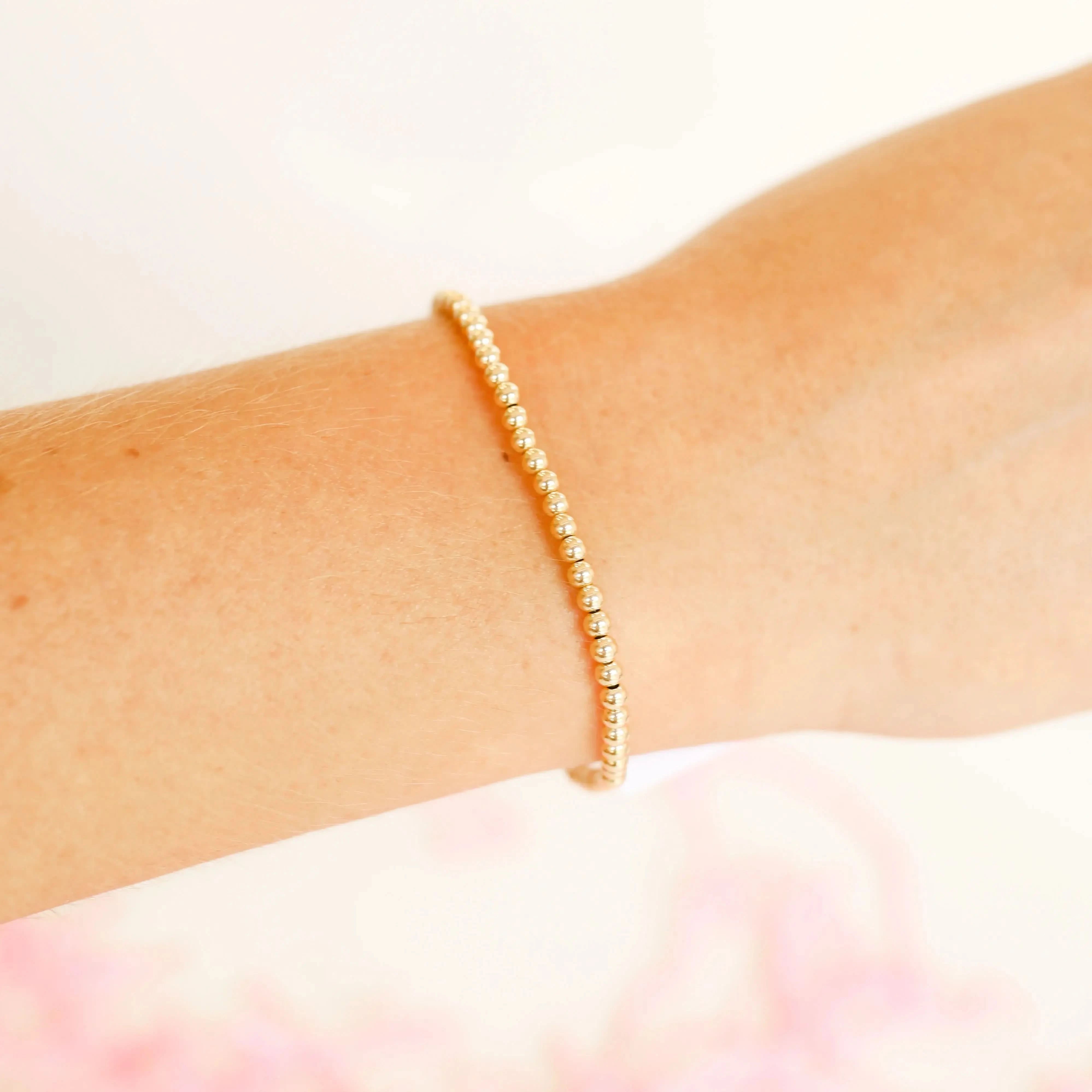 14K Gold Filled Beaded Bracelet Gold bracelet on a wrist with a soft pink 