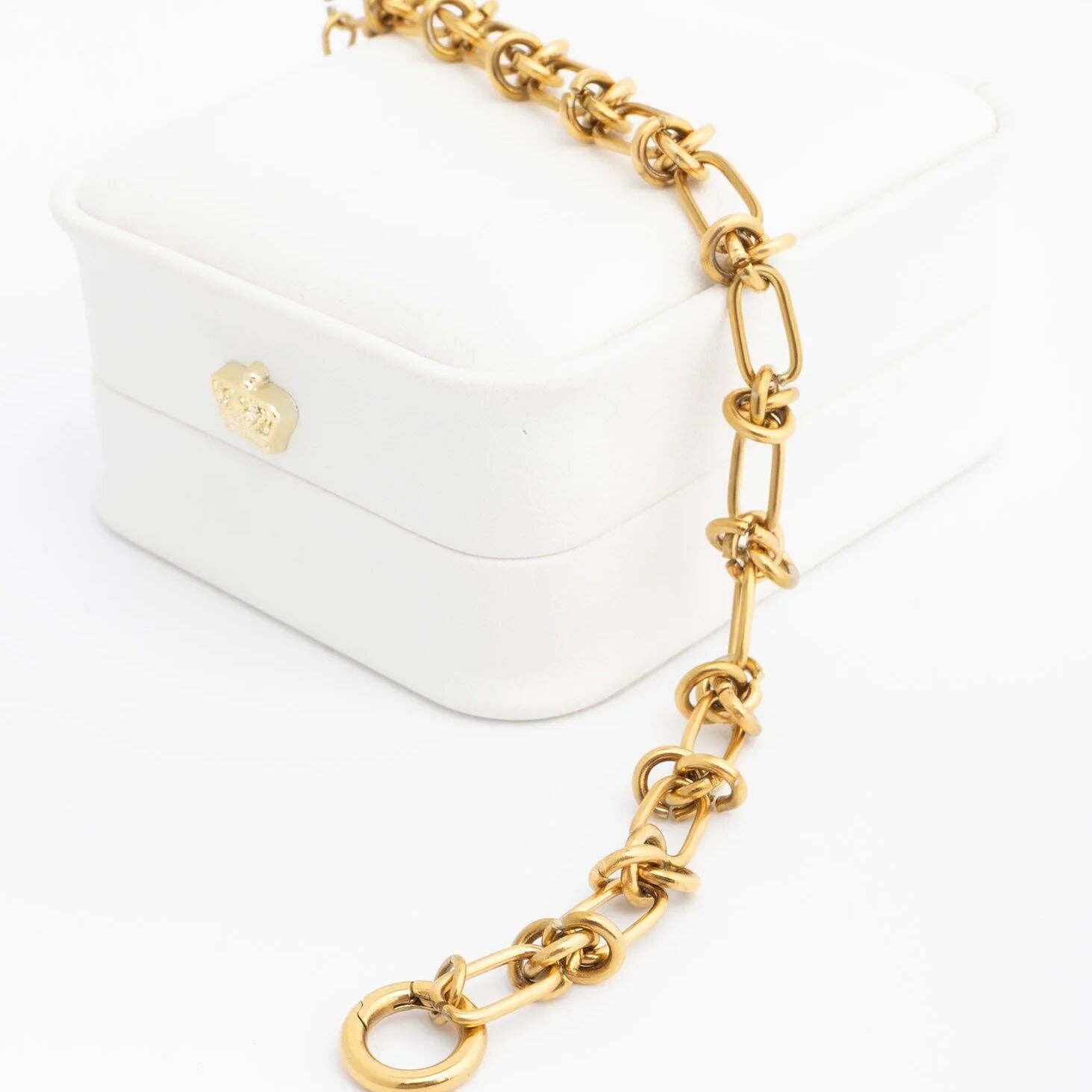 Gold chain accessory on a white handbag