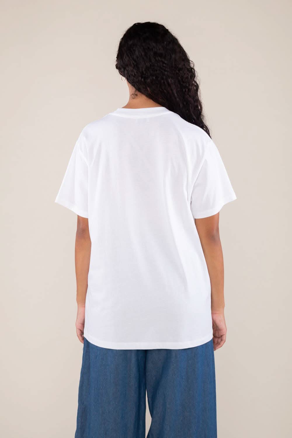 Woman wearing white boxy, oversized, shirt sleeved, tee t-shirt and jeans