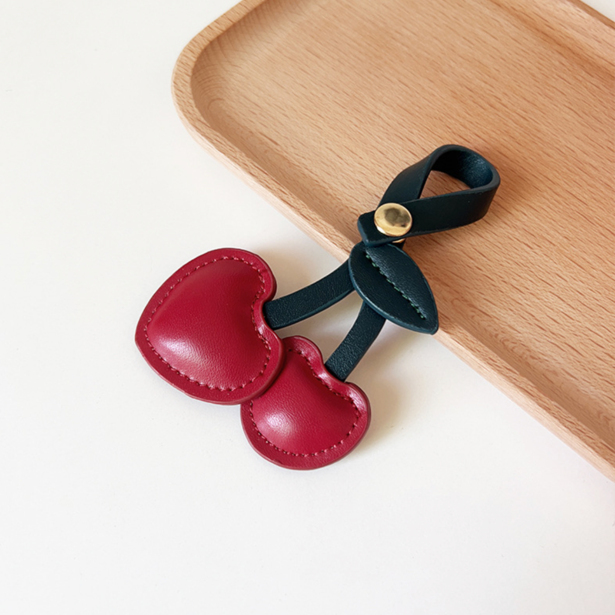 Two, red, leather, heart shaped, cherries with dark black leaf and looped stem and gold button clasp to use as bag charm