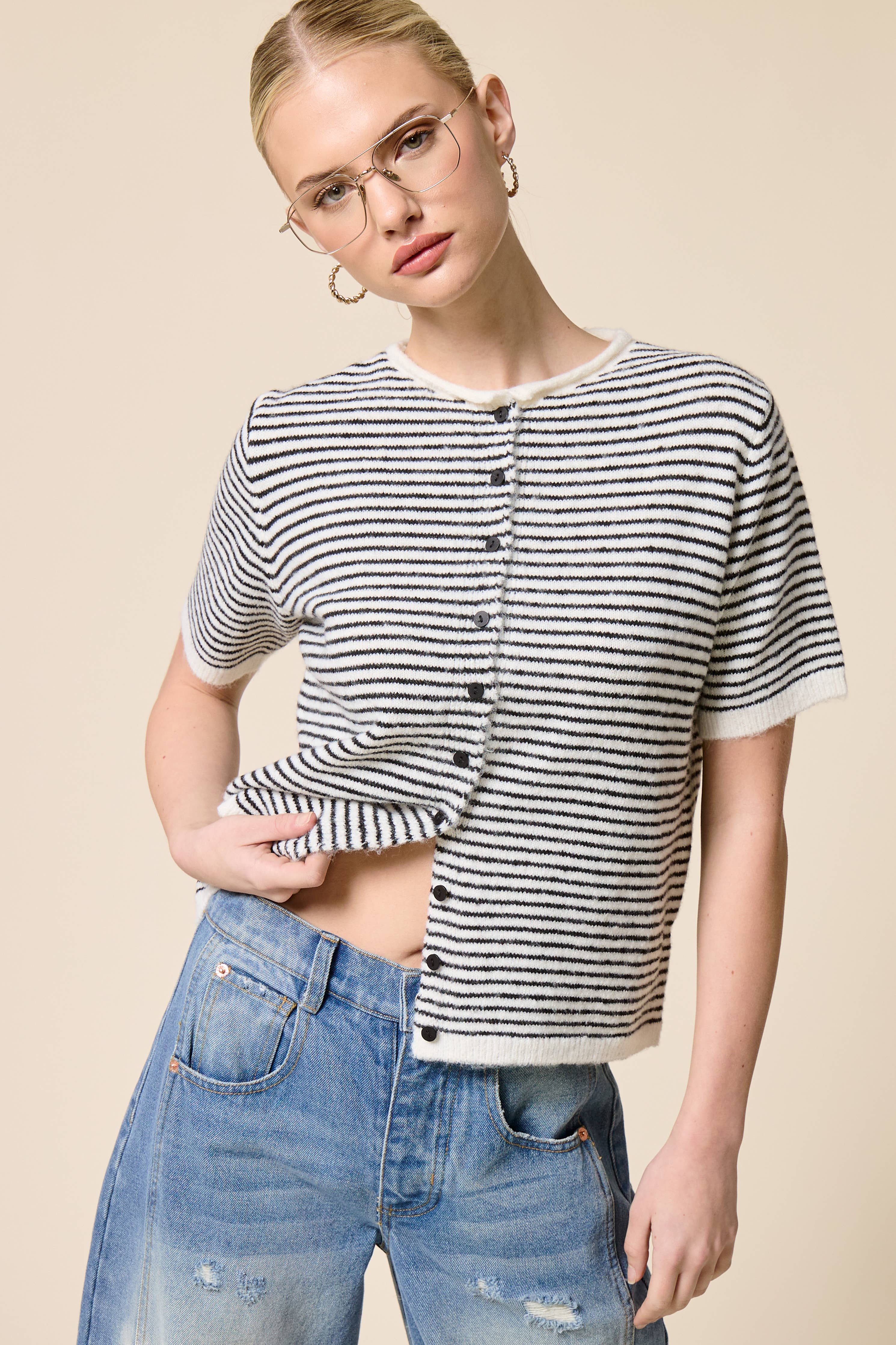 Woman wearing a black and white striped shirt with a beige background