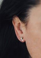 woman wearing gold dip clear quartz stud earrings 