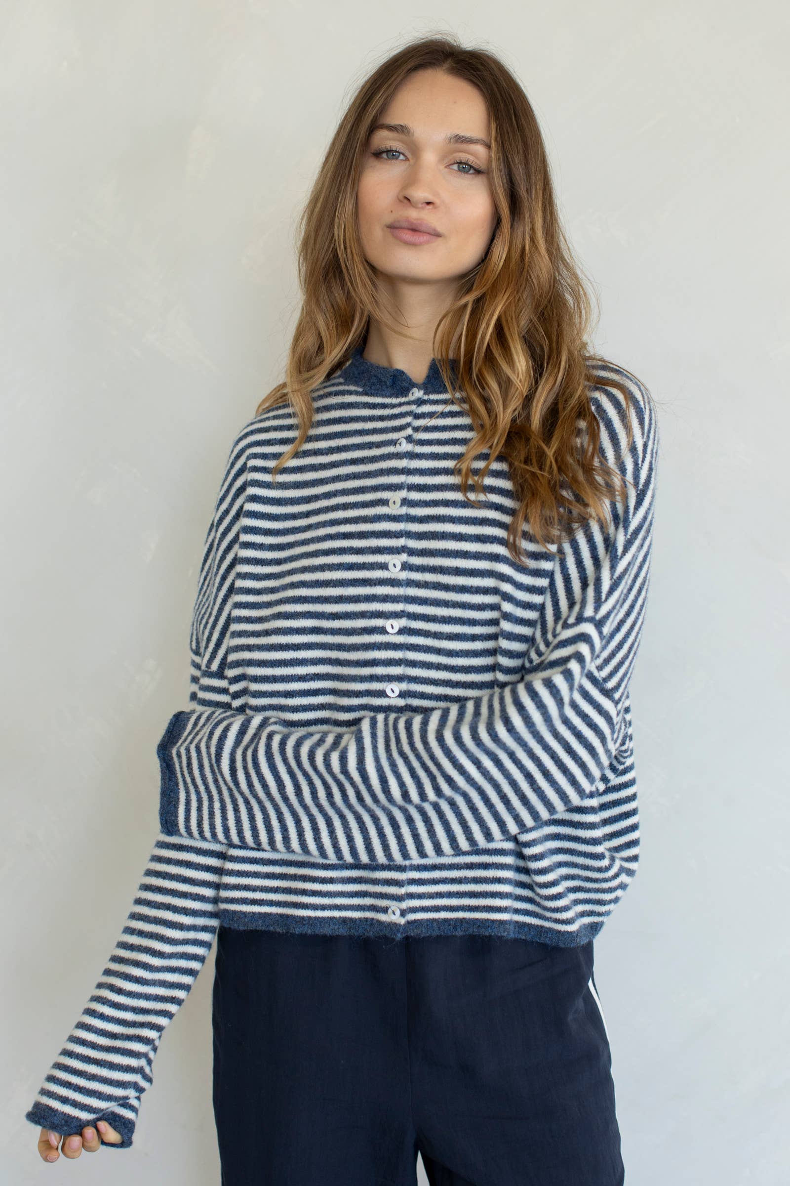 Woman wearing a blue and white striped shirt against a plain background