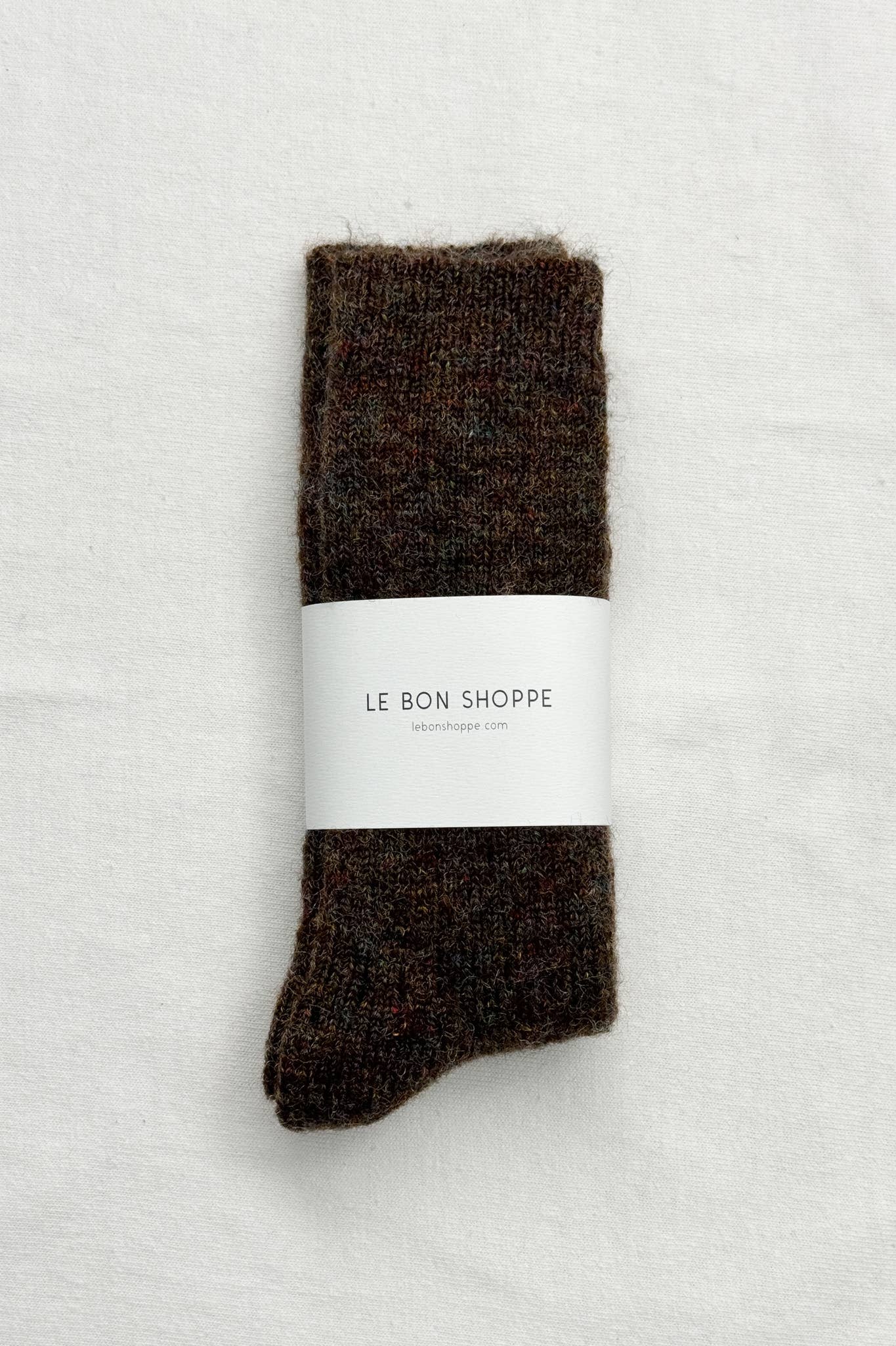 Pair of brown socks with a white label on a light gray background