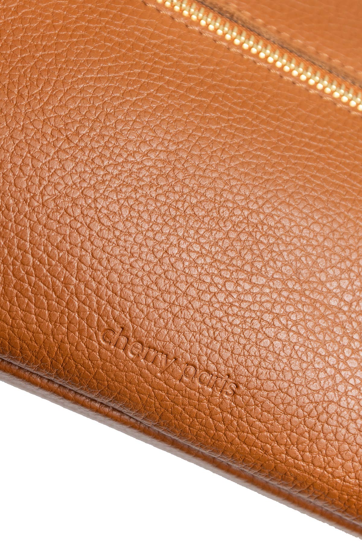 Close-up of a tan pebbled leather clutch or wallet with a gold-tone zipper and debossed 'chloé paris' branding, shown on a white background.