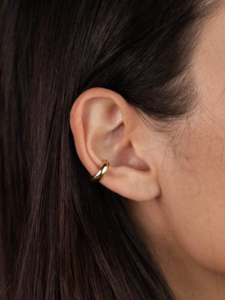 woman wearing gold earring smooth cuff