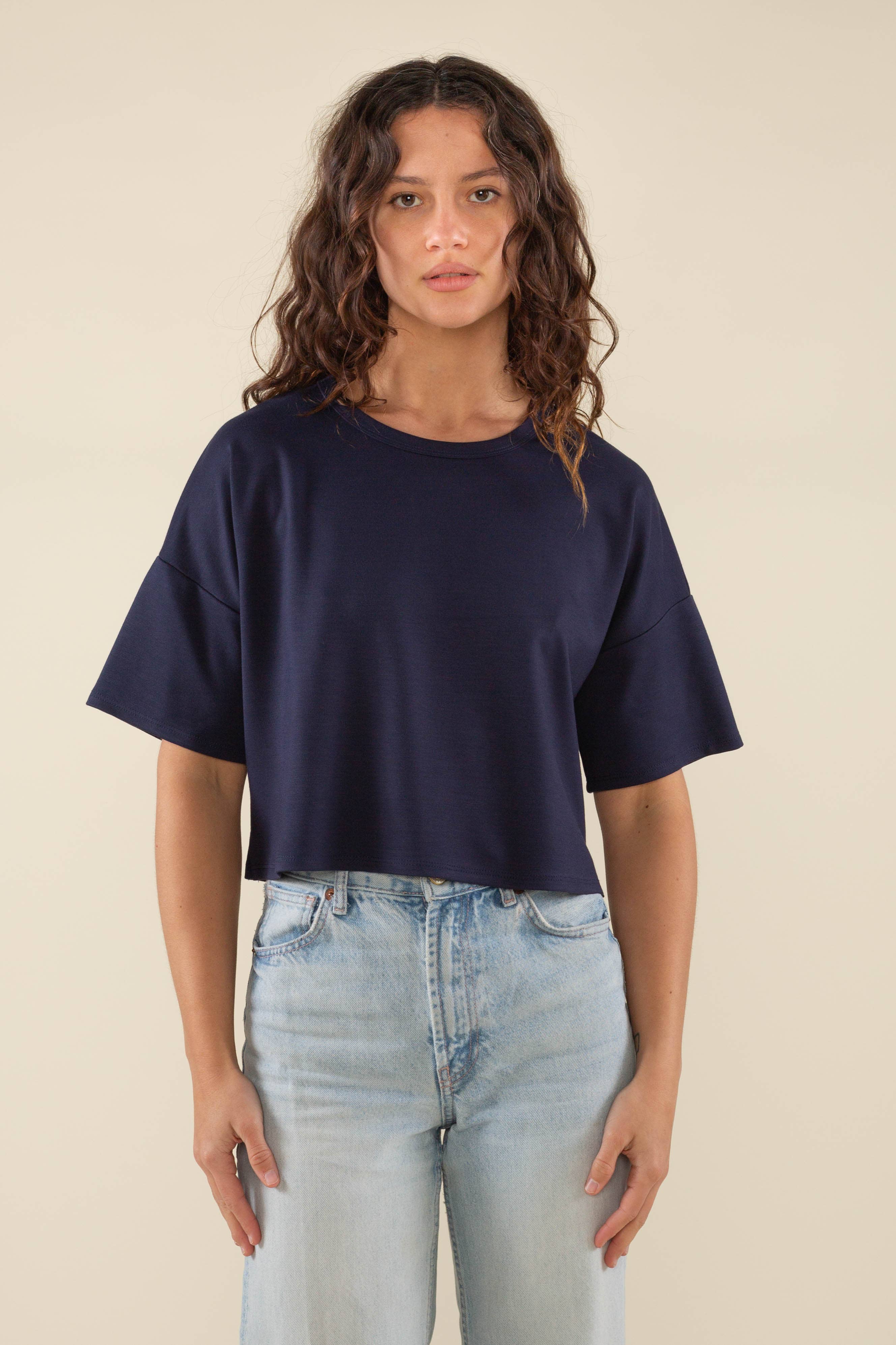 Woman wearing navy, short sleeve, jersey, cropped t-shirt and blue jeans 
