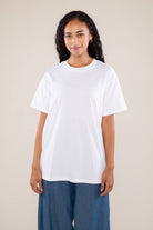 Woman wearing white boxy, oversized, shirt sleeved, tee t-shirt and jeans 