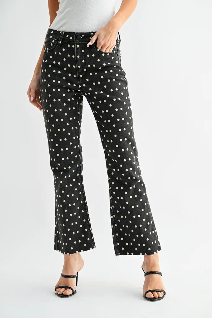 Black jeans with white polka dots worn by a person on a white background